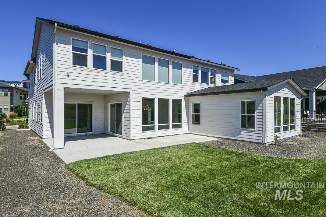 Rear view of house with a patio area and a lawn