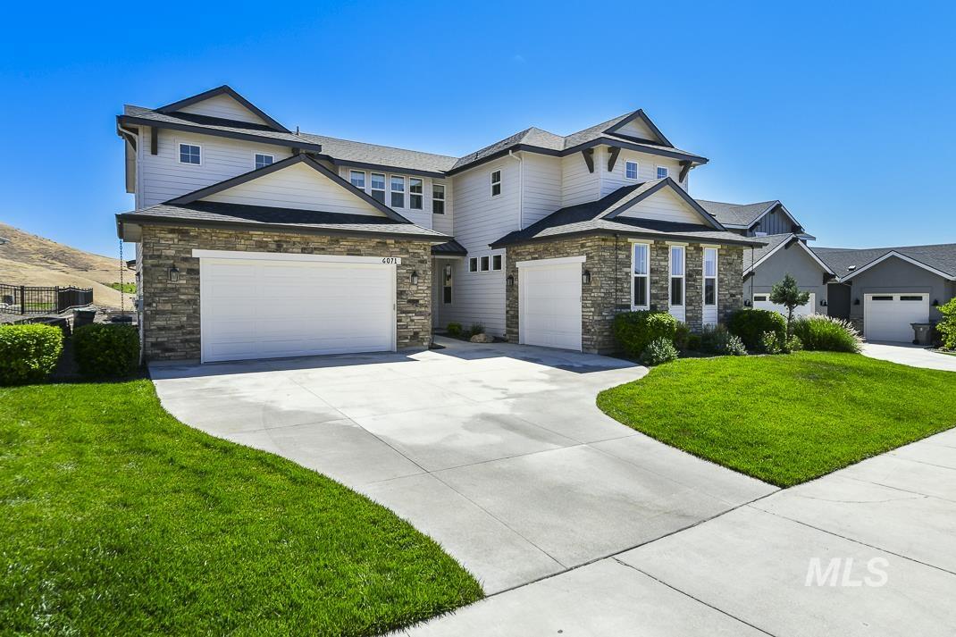 Craftsman inspired home featuring driveway, a front yard, stone siding, and a garage