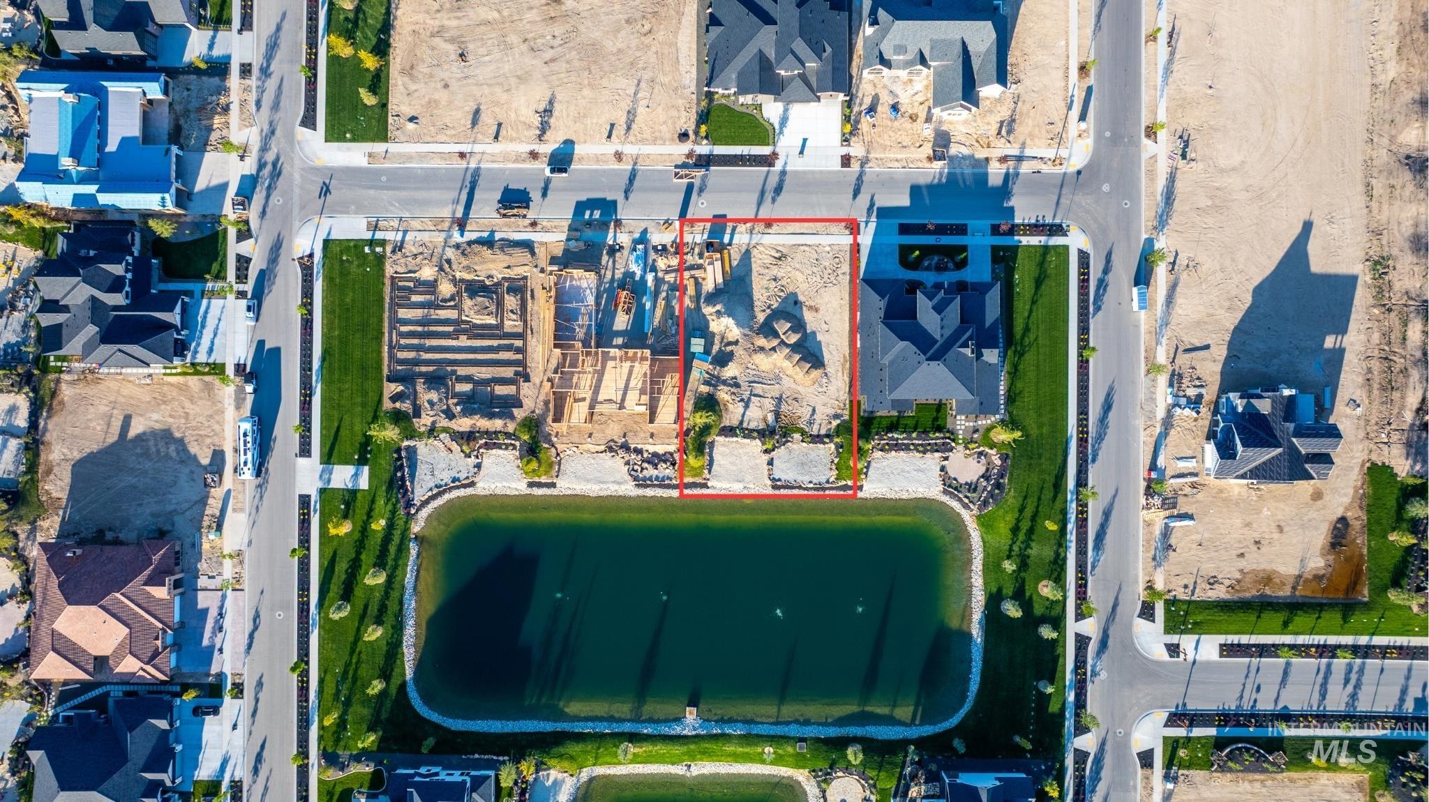 Aerial perspective of suburban area with property boundaries highlighted and a nearby body of water