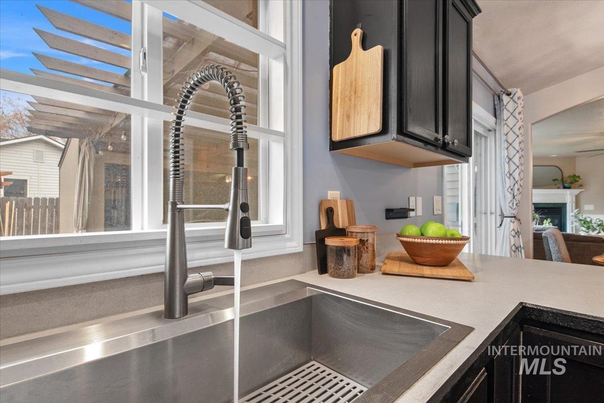 Kitchen view of dark cabinets and a fireplace
