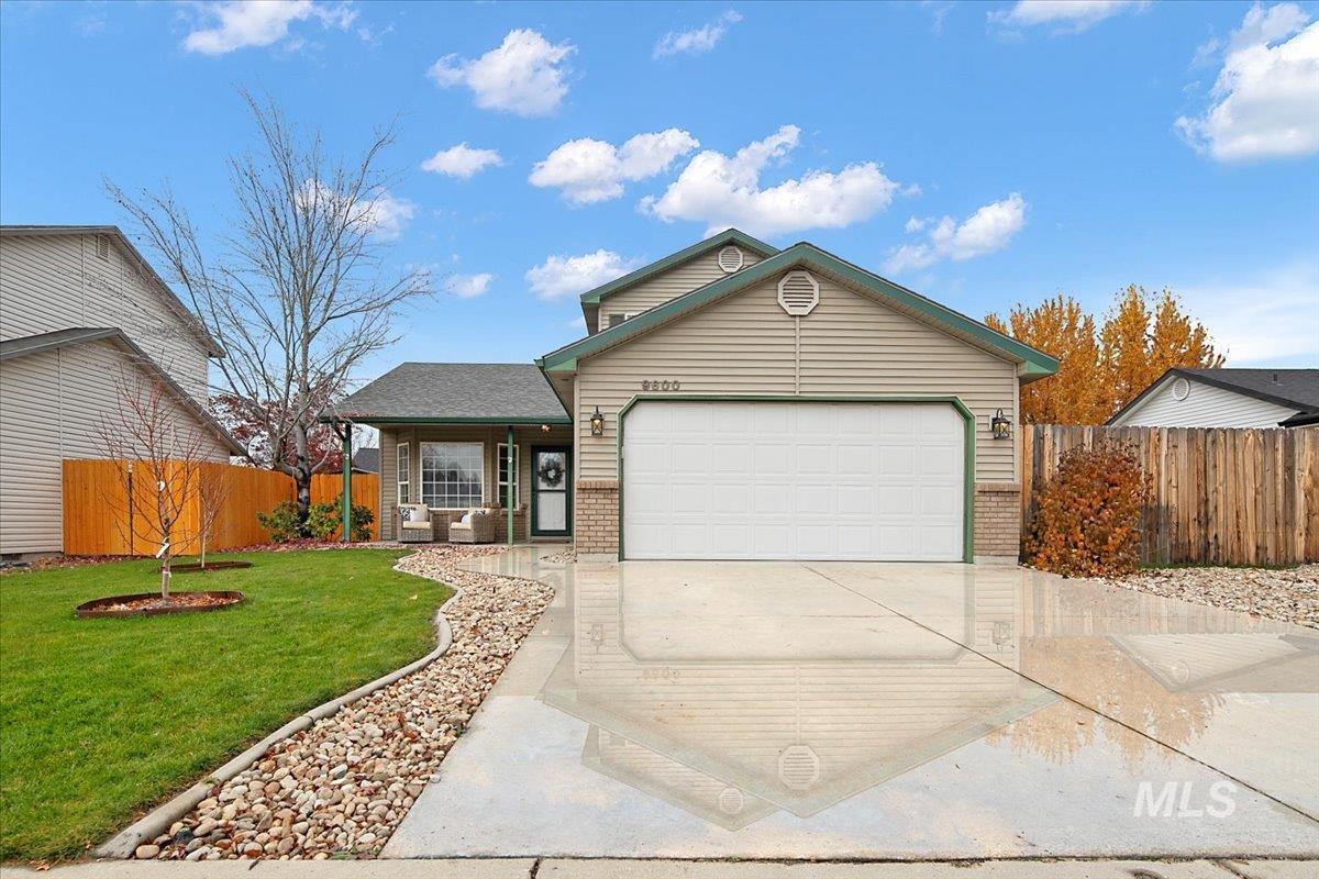 Ranch-style house with brick siding, a garage, driveway, and covered porch