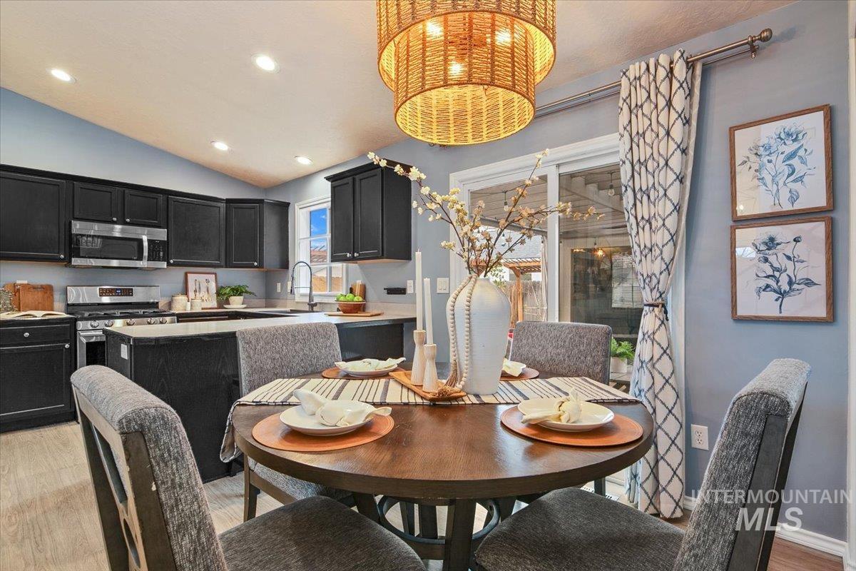 Dining room featuring light wood-style floors, vaulted ceiling, and recessed lighting