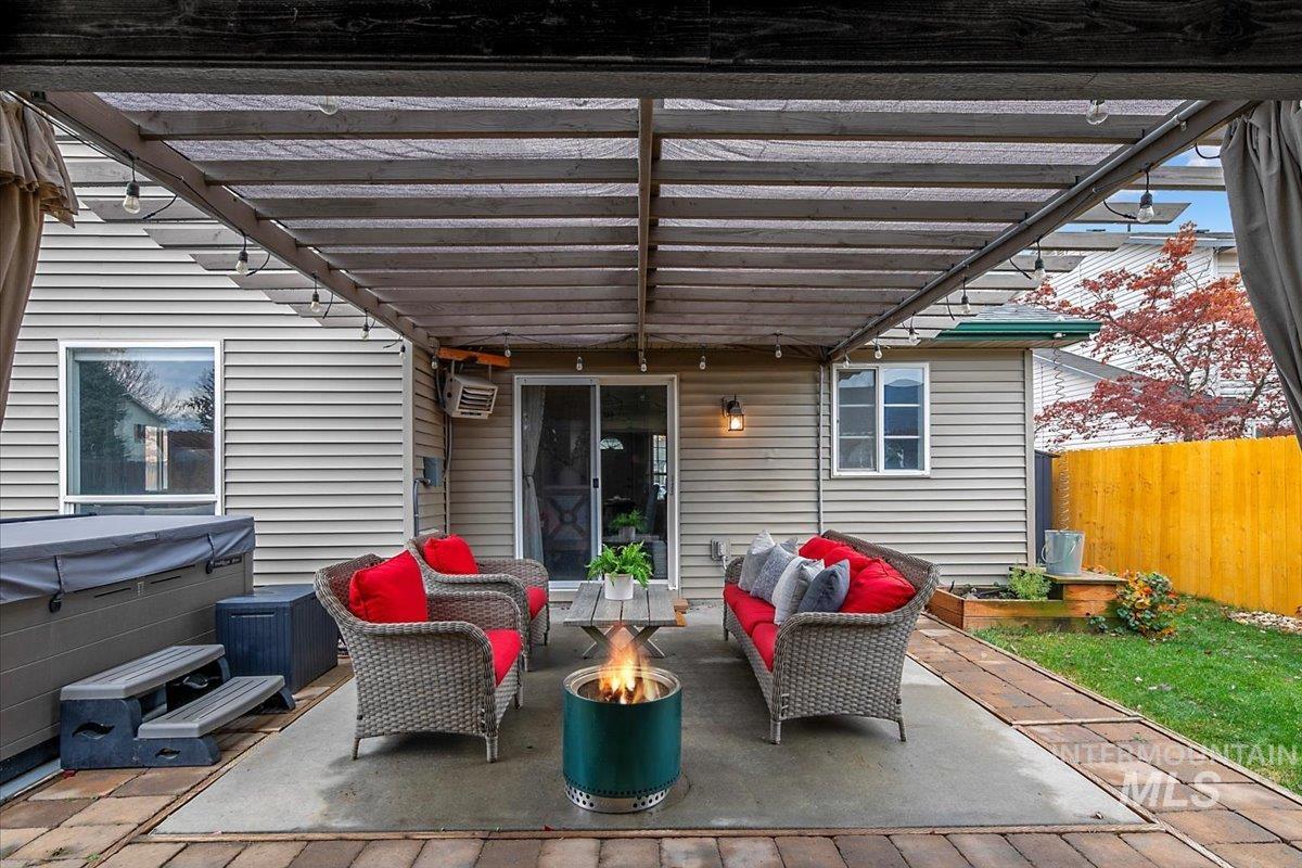 View of patio / terrace with a pergola, an outdoor living space with a fire pit, and a hot tub