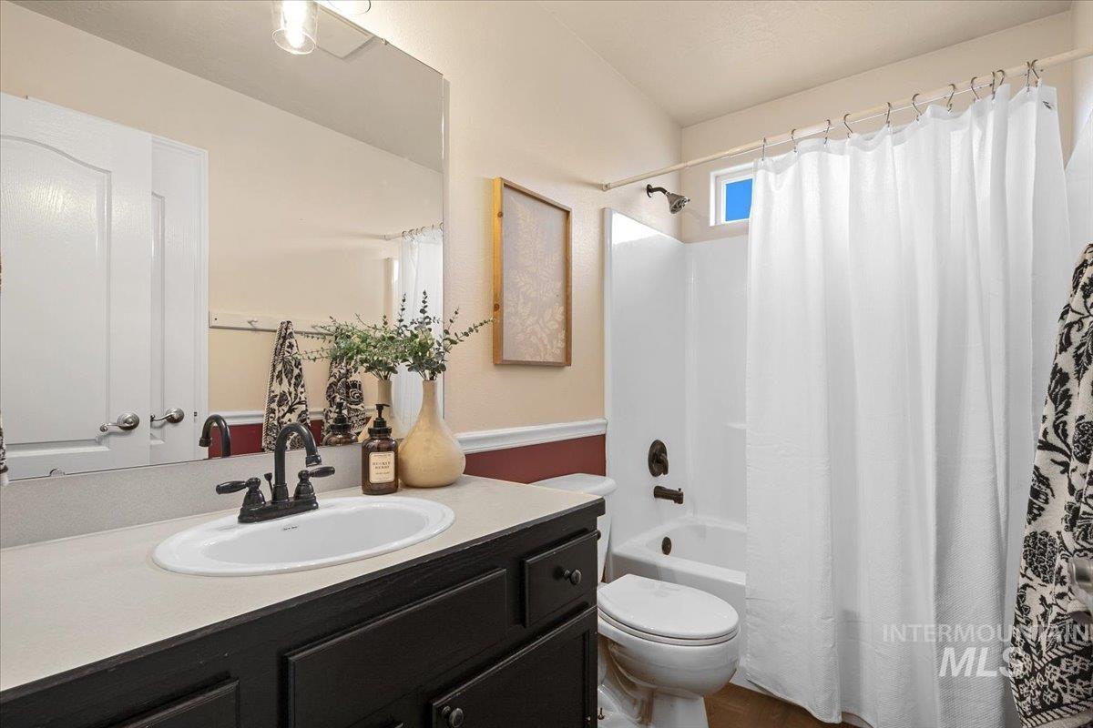 Bathroom with vanity and shower / bath combo with shower curtain