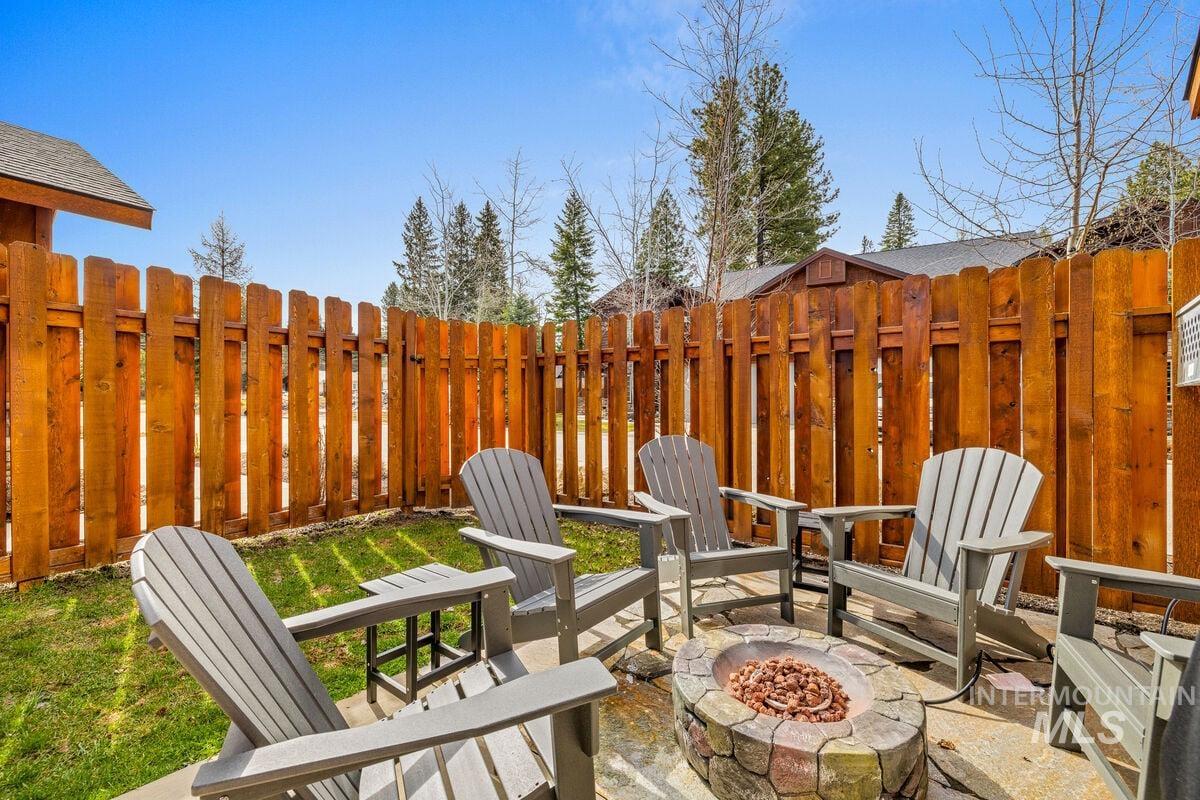 Fenced backyard featuring a fire pit and a patio