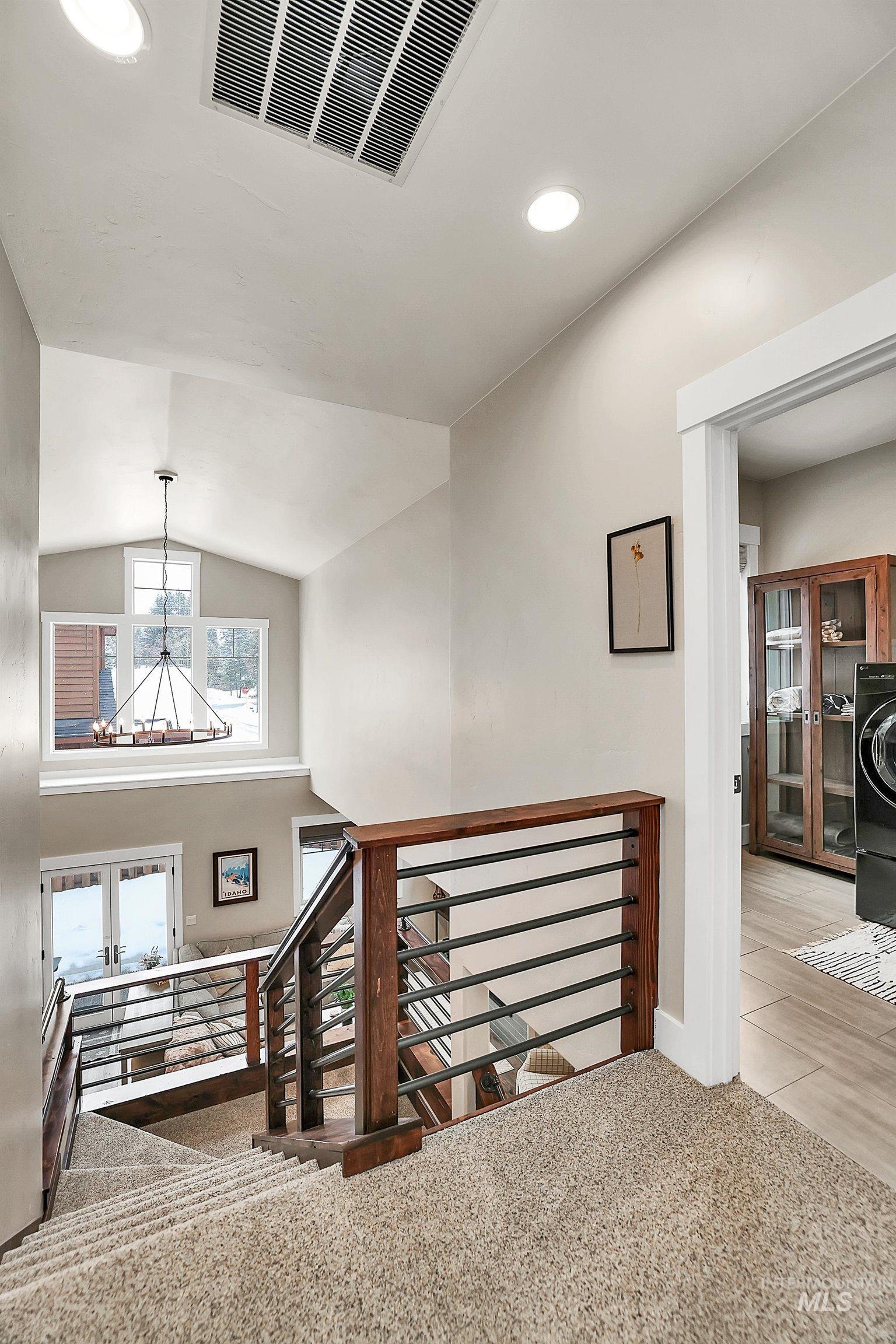 Staircase with french doors, recessed lighting, and carpet