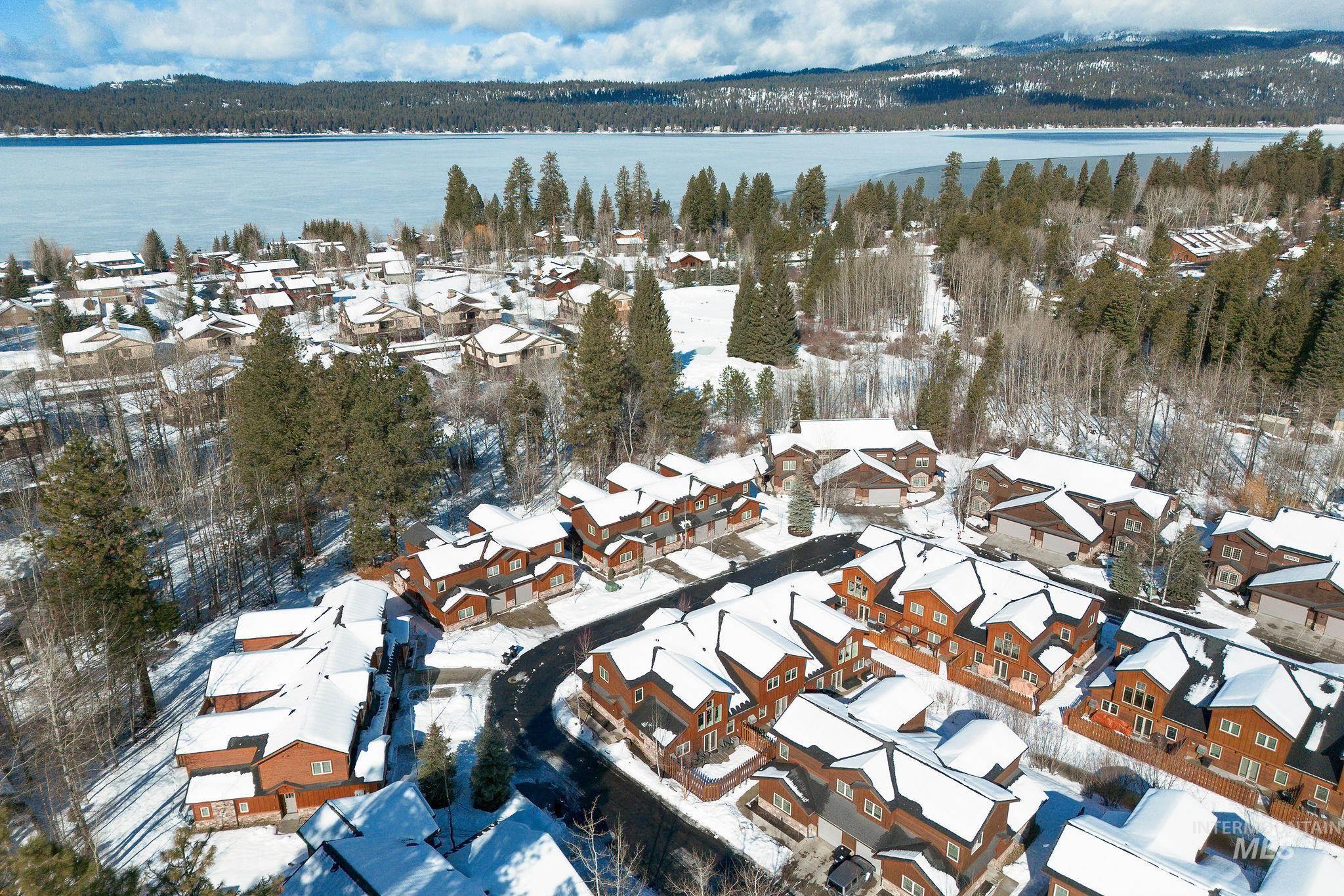 Snowy aerial view featuring a residential view and a water view