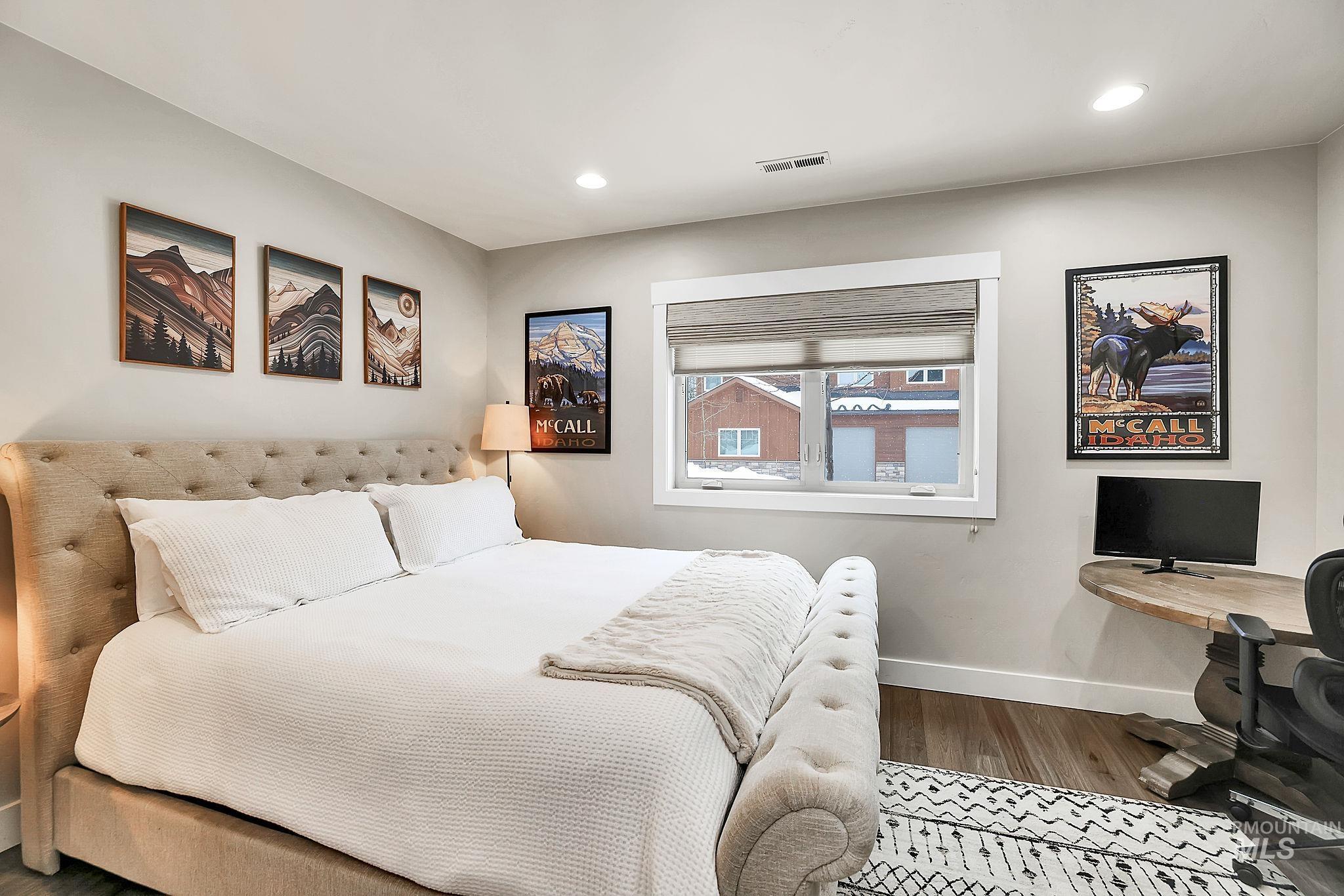 Bedroom with a desk, wood finished floors, and recessed lighting