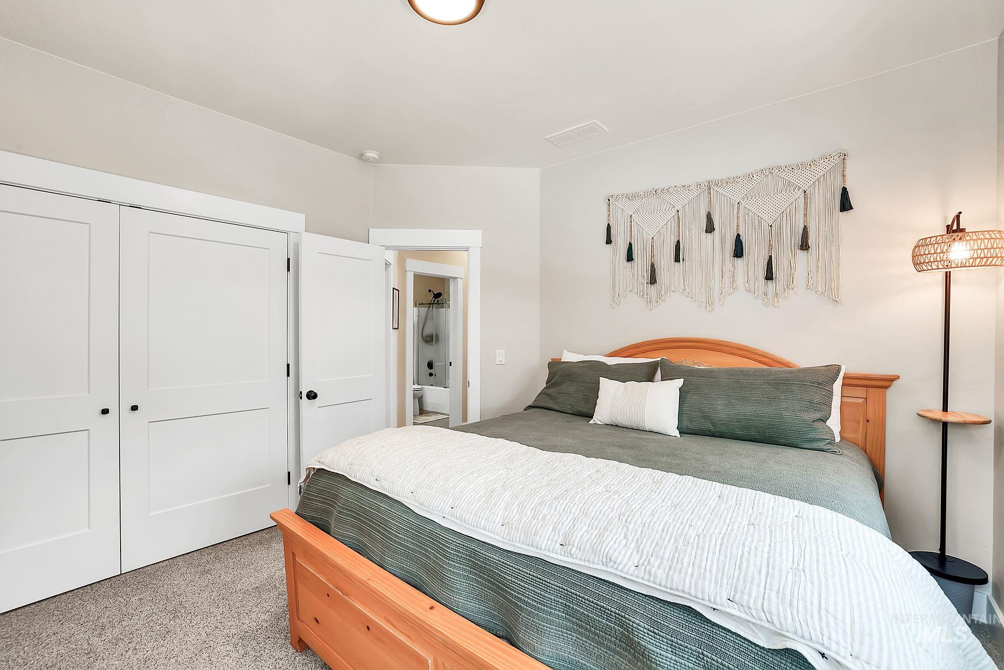 Bedroom with light carpet and a closet