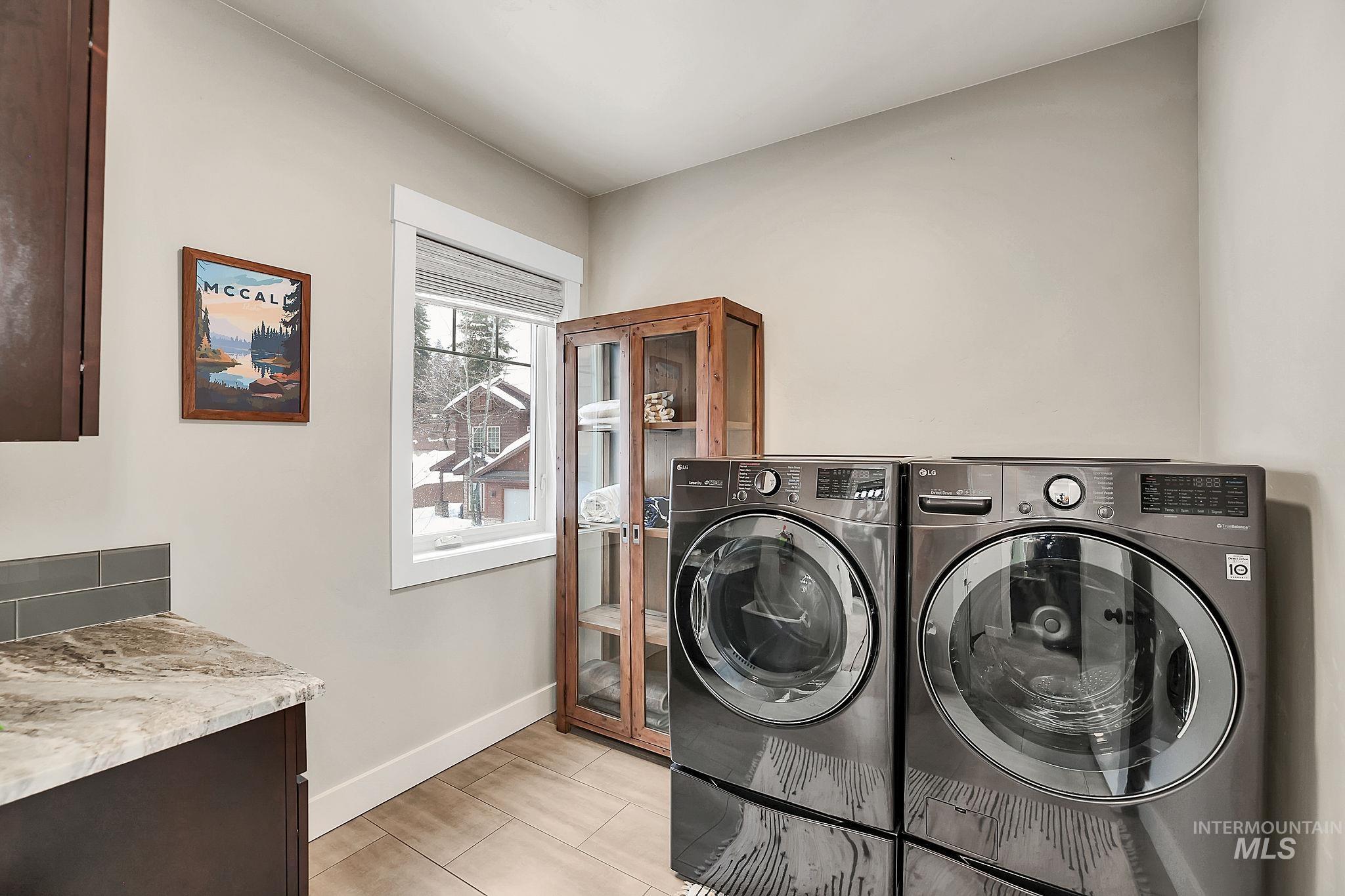 Laundry room with baseboards and washer and dryer
