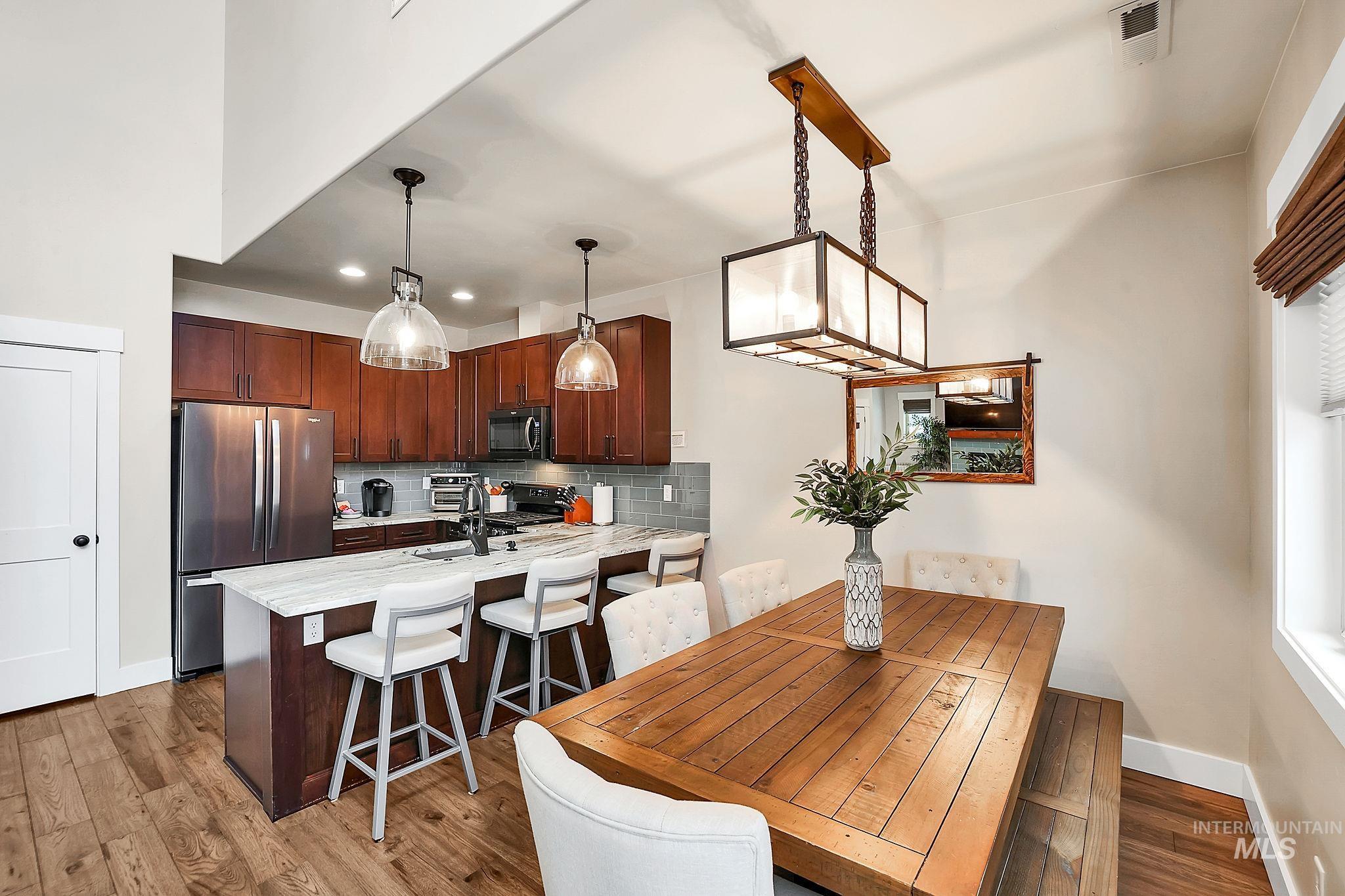 Dining space featuring dark wood-style flooring and recessed lighting