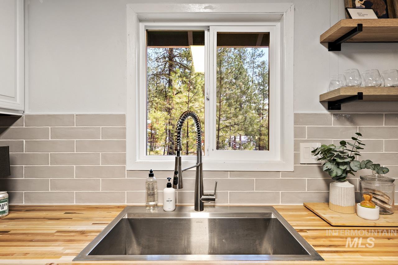 Kitchen view of wood counters, open shelves, and decorative backsplash