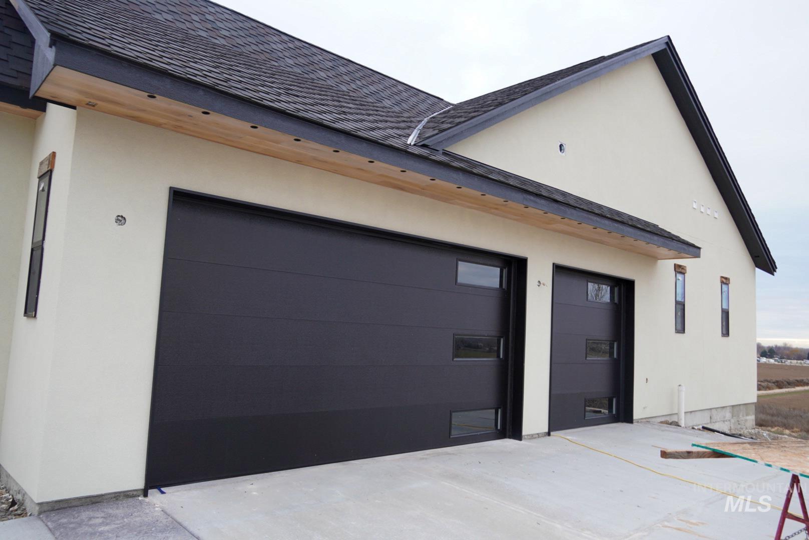 View of property exterior featuring stucco siding, concrete driveway, and a garage