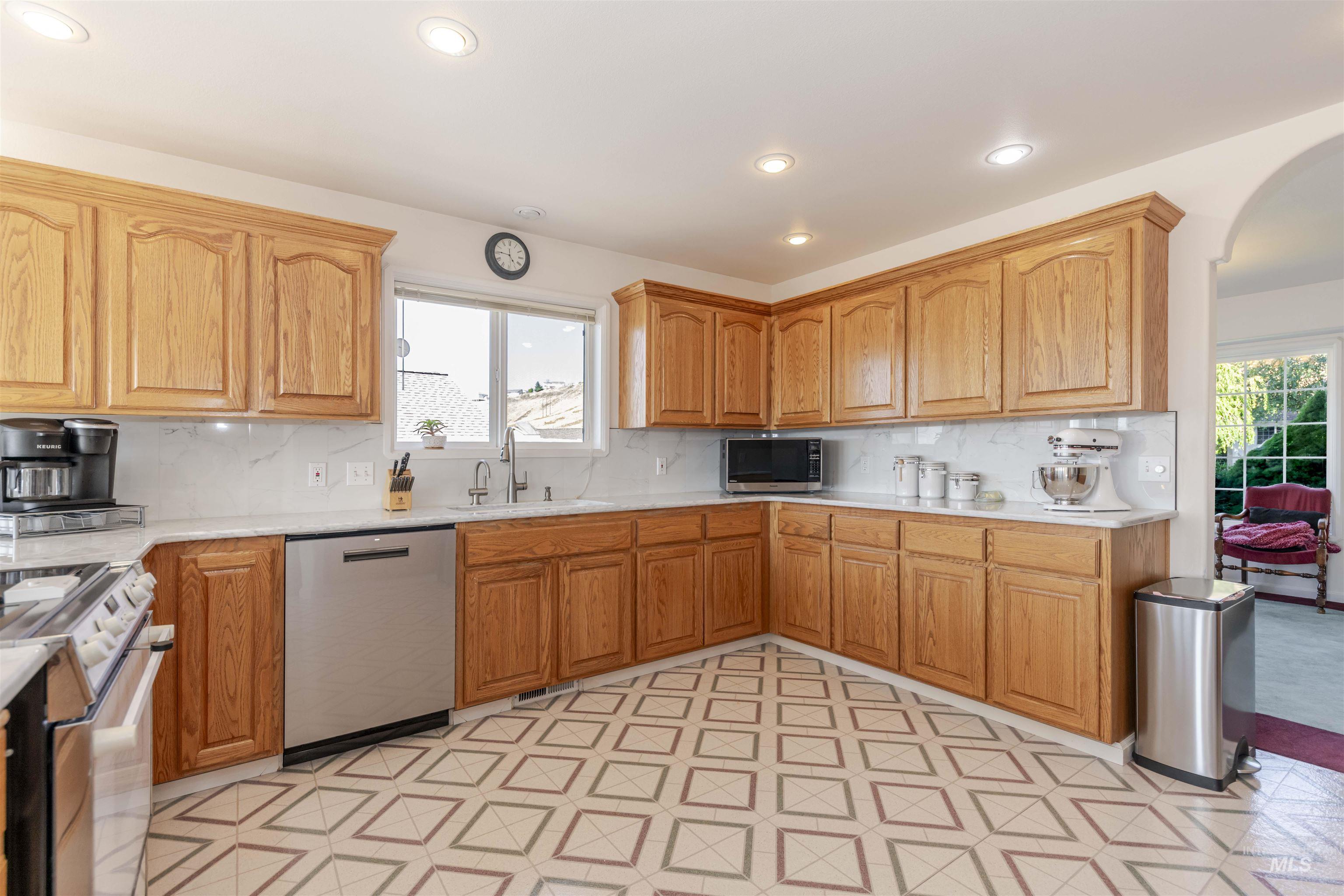 Kitchen featuring appliances with stainless steel finishes, decorative backsplash, recessed lighting, and healthy amount of natural light