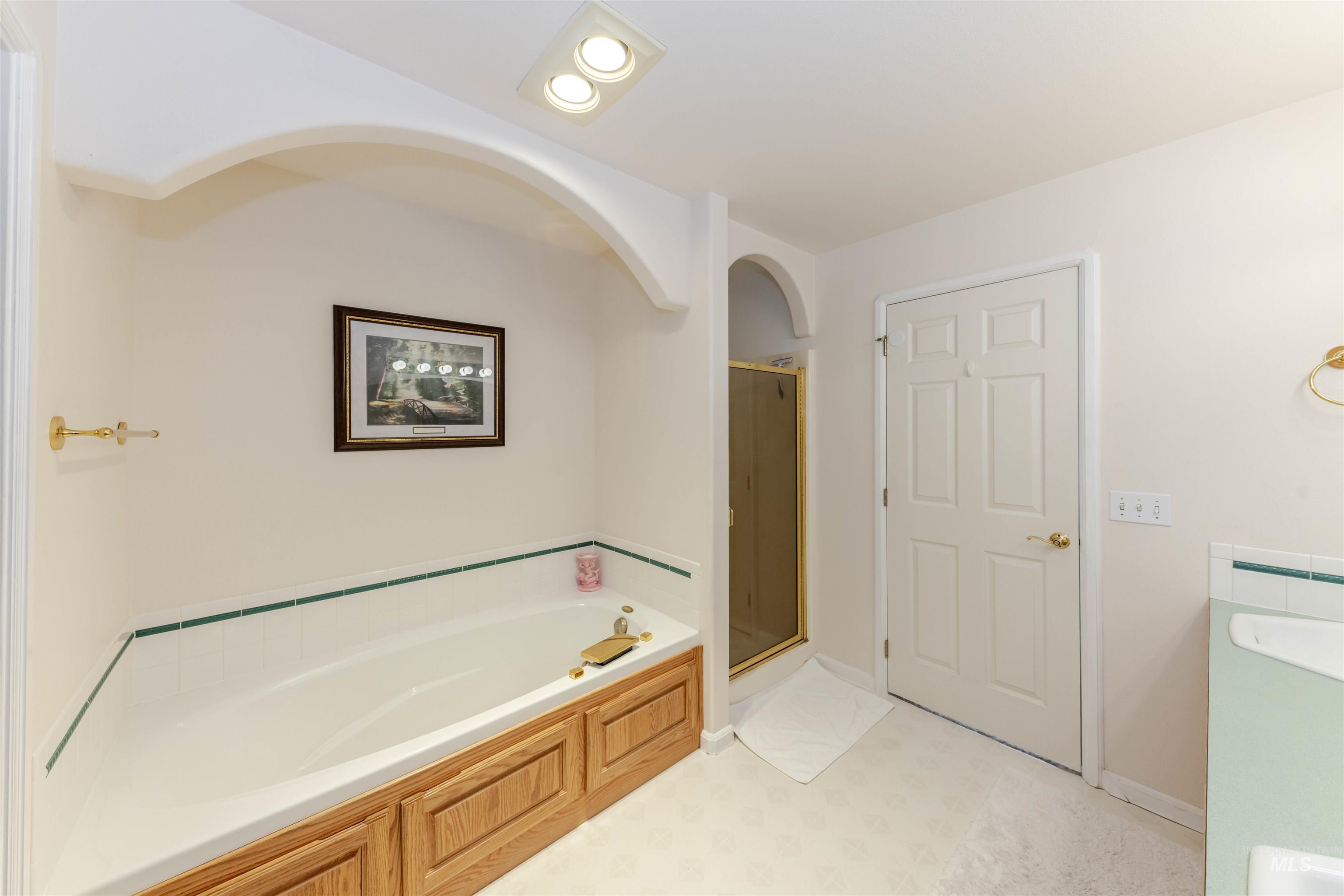 Full bathroom featuring vanity, a bath, and a shower stall