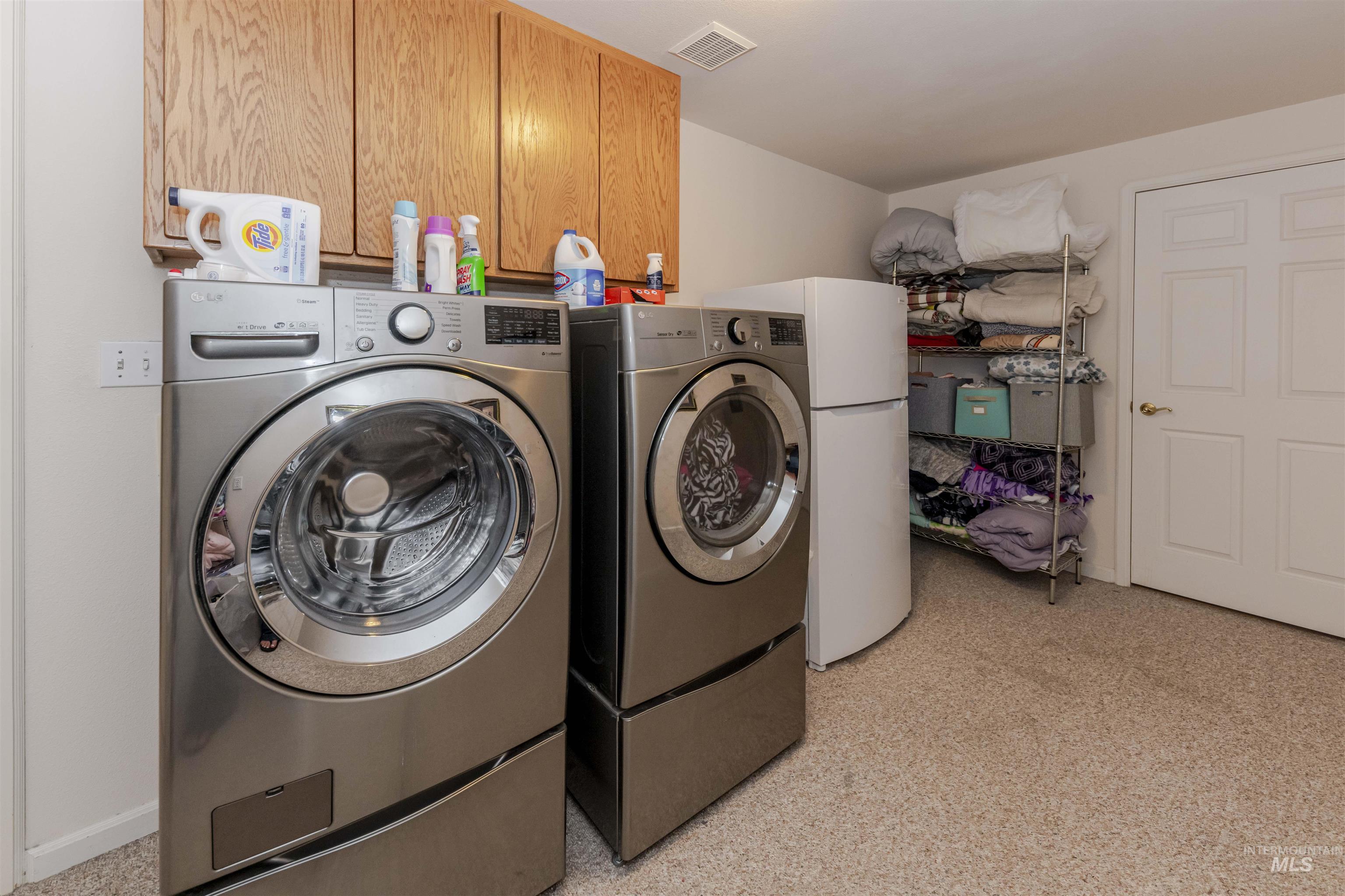 Washroom with washing machine and clothes dryer and cabinet space