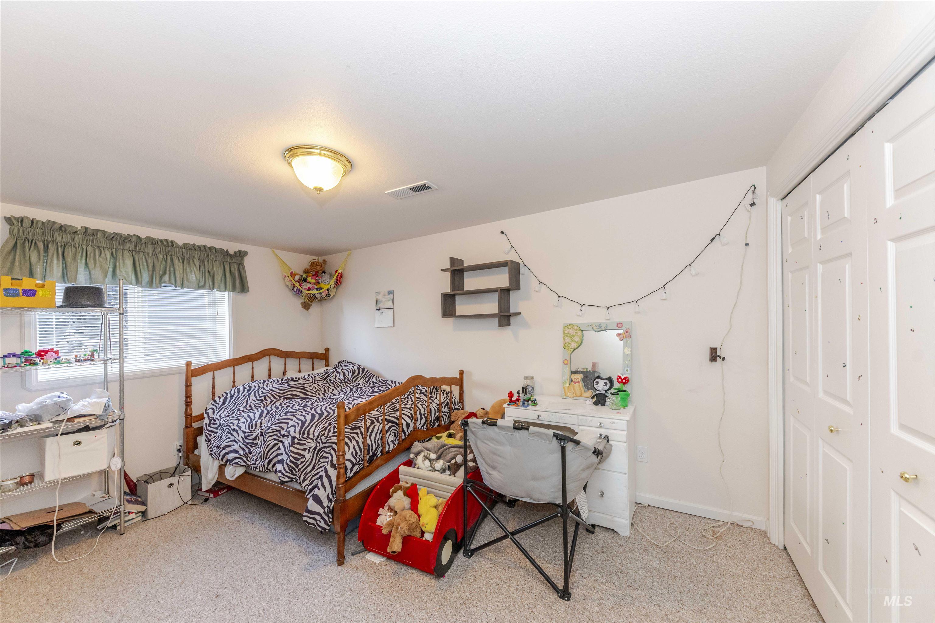 Bedroom featuring light colored carpet and a closet
