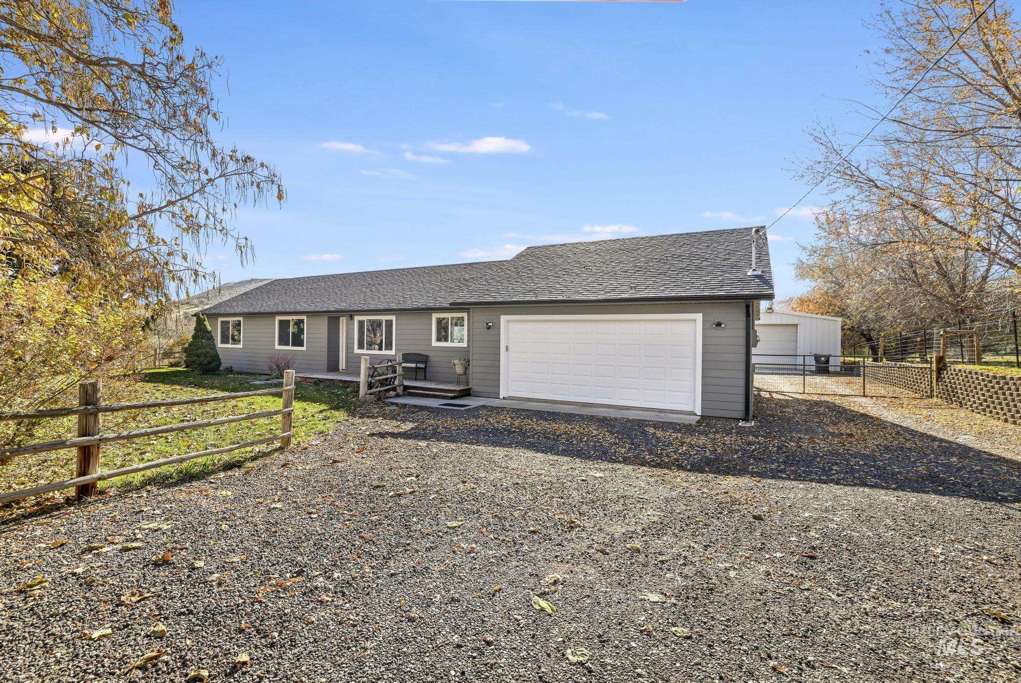 Ranch-style home featuring a shingled roof, driveway, and an attached garage