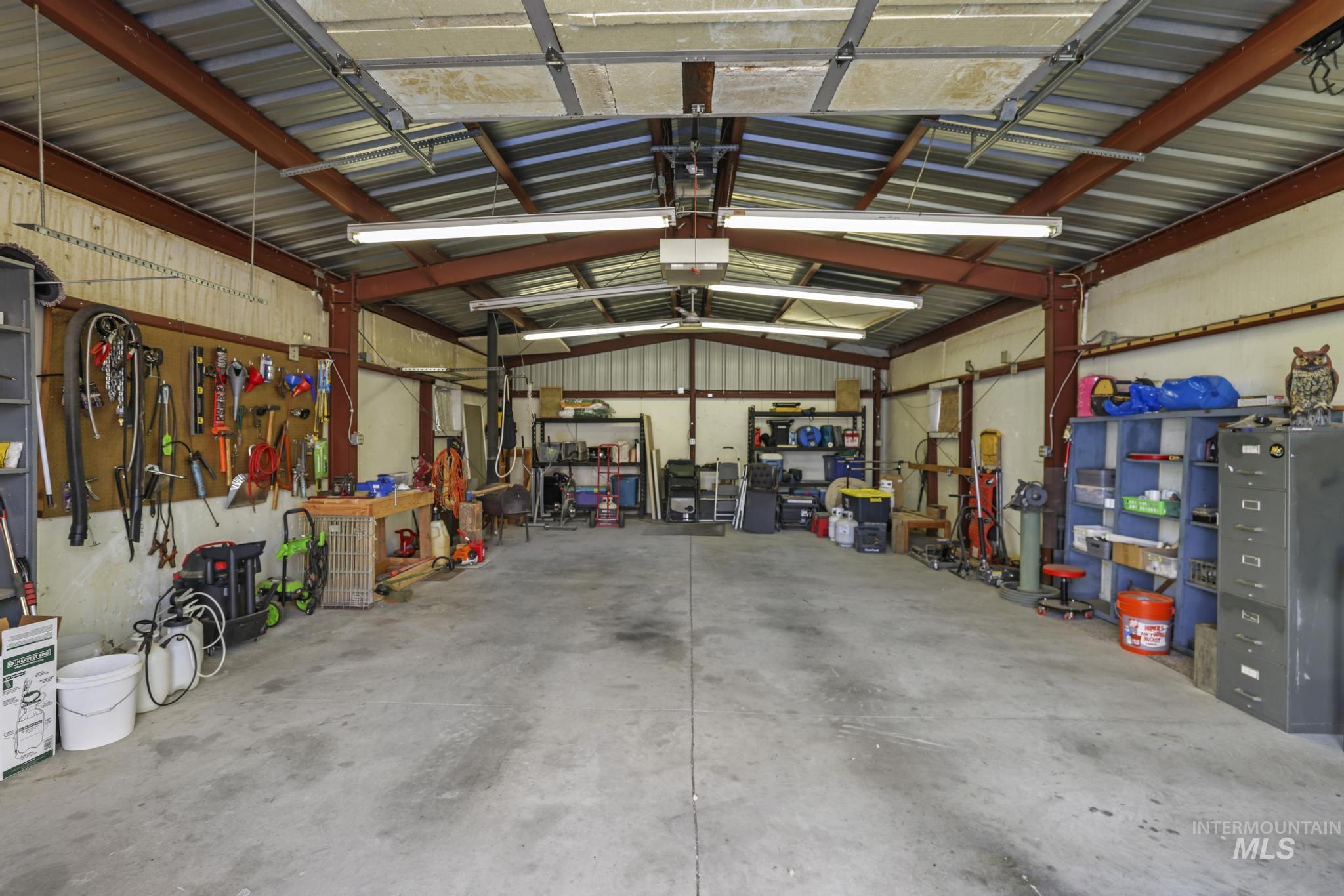 Garage featuring a workshop area, metal wall, and a garage door opener