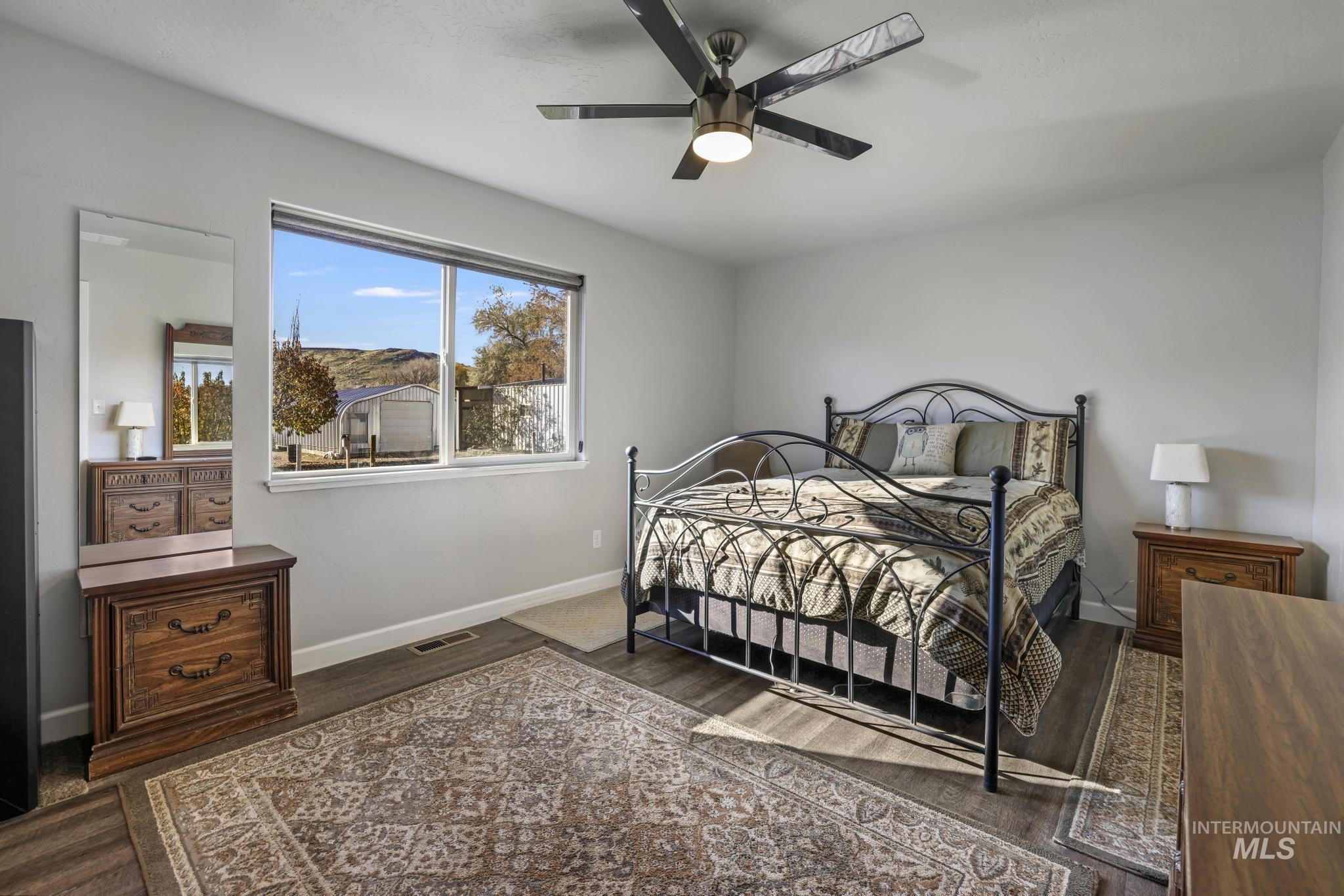 Bedroom featuring a ceiling fan and dark wood-type flooring