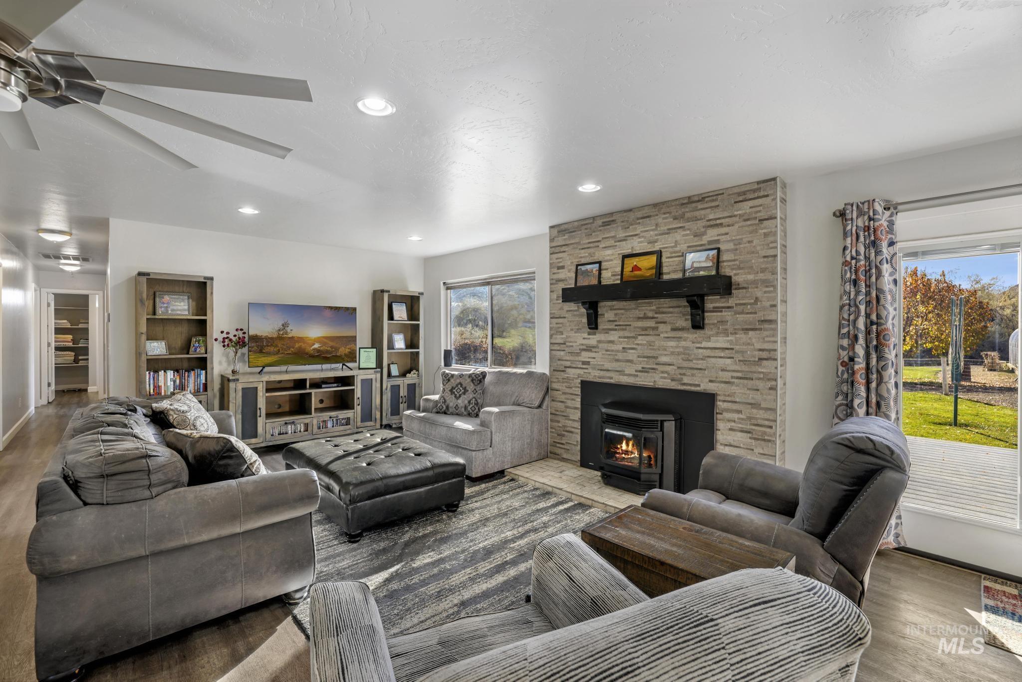 Living room featuring wood finished floors, recessed lighting, and a fireplace