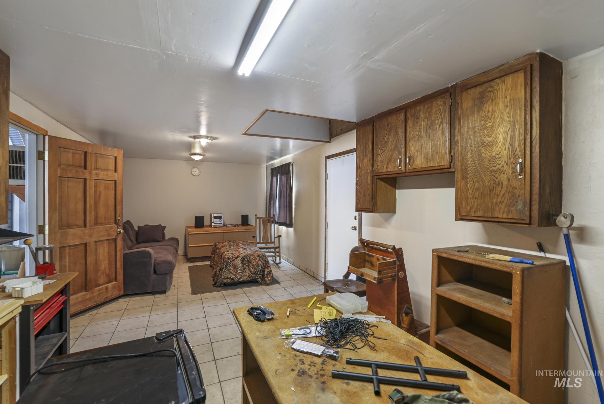Kitchen featuring light tile patterned floors, brown cabinets, open floor plan, and light countertops