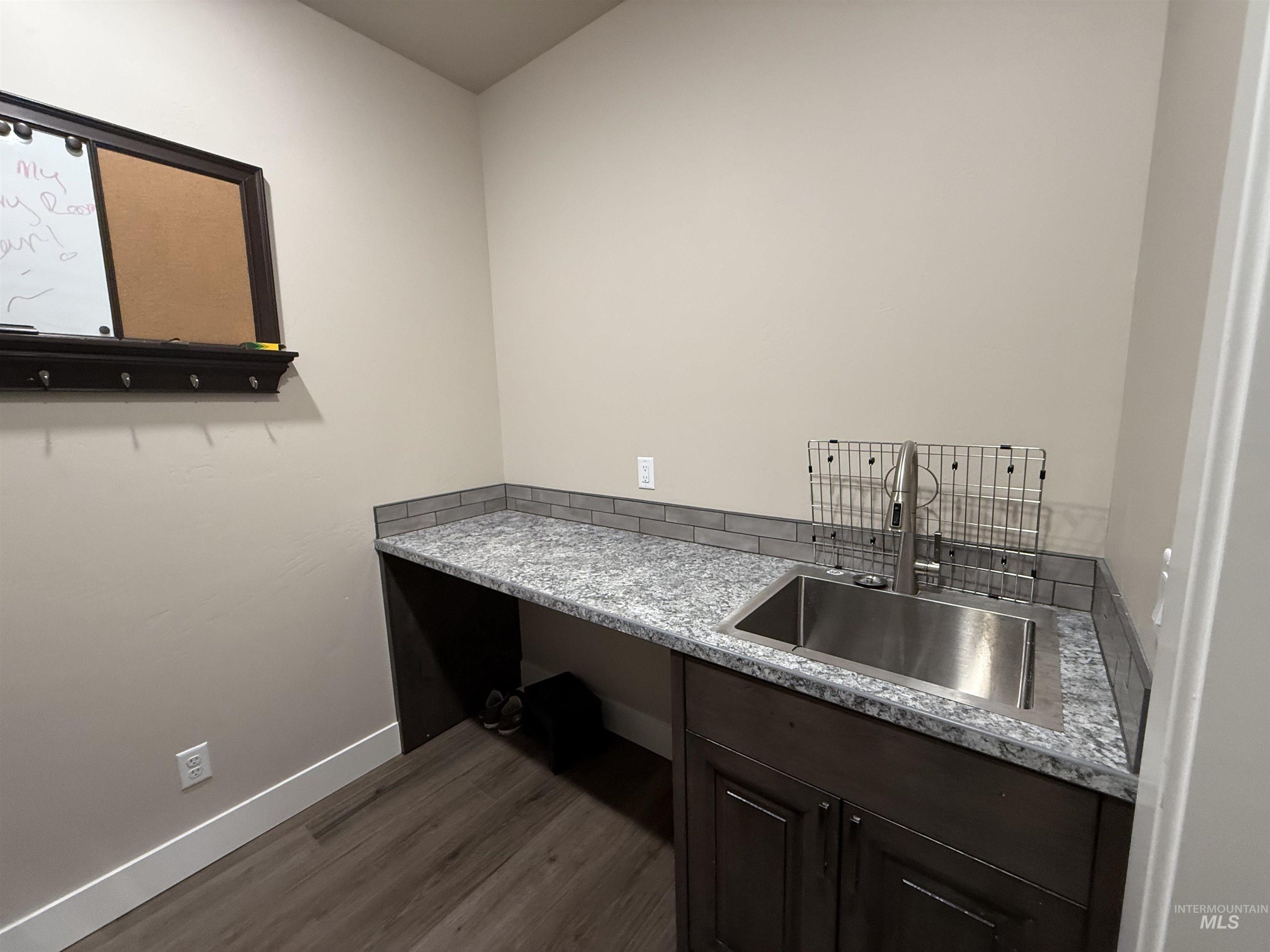 Washroom with a sink and dark wood-style floors