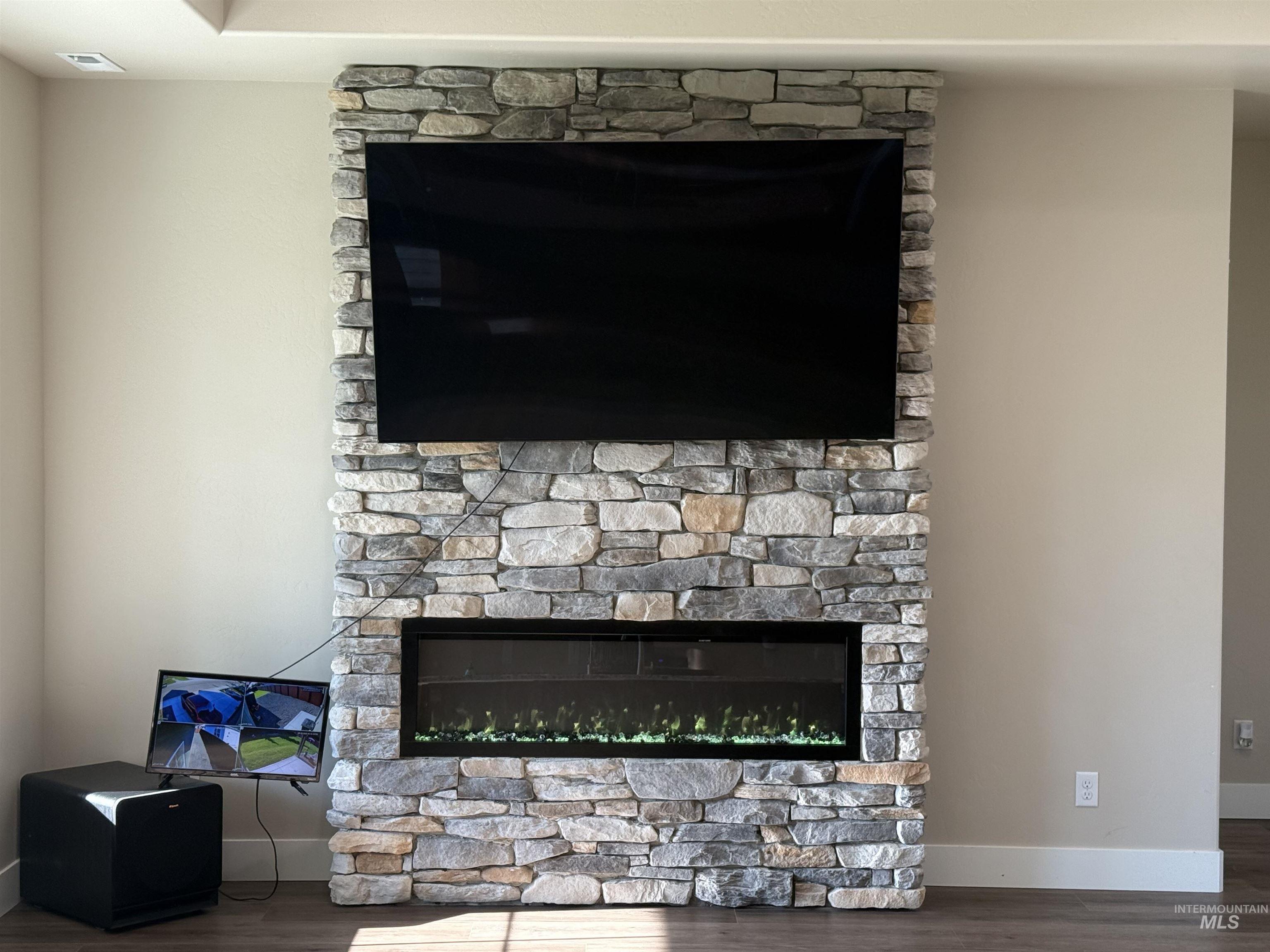 Detailed view of a fireplace and wood finished floors
