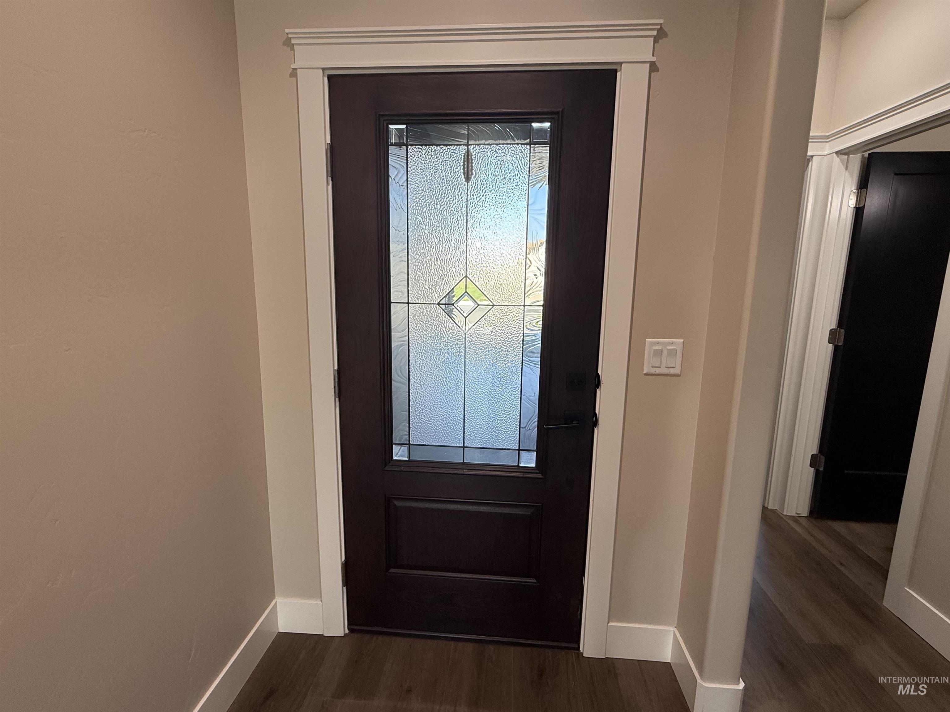 Doorway to outside featuring wood finished floors and baseboards