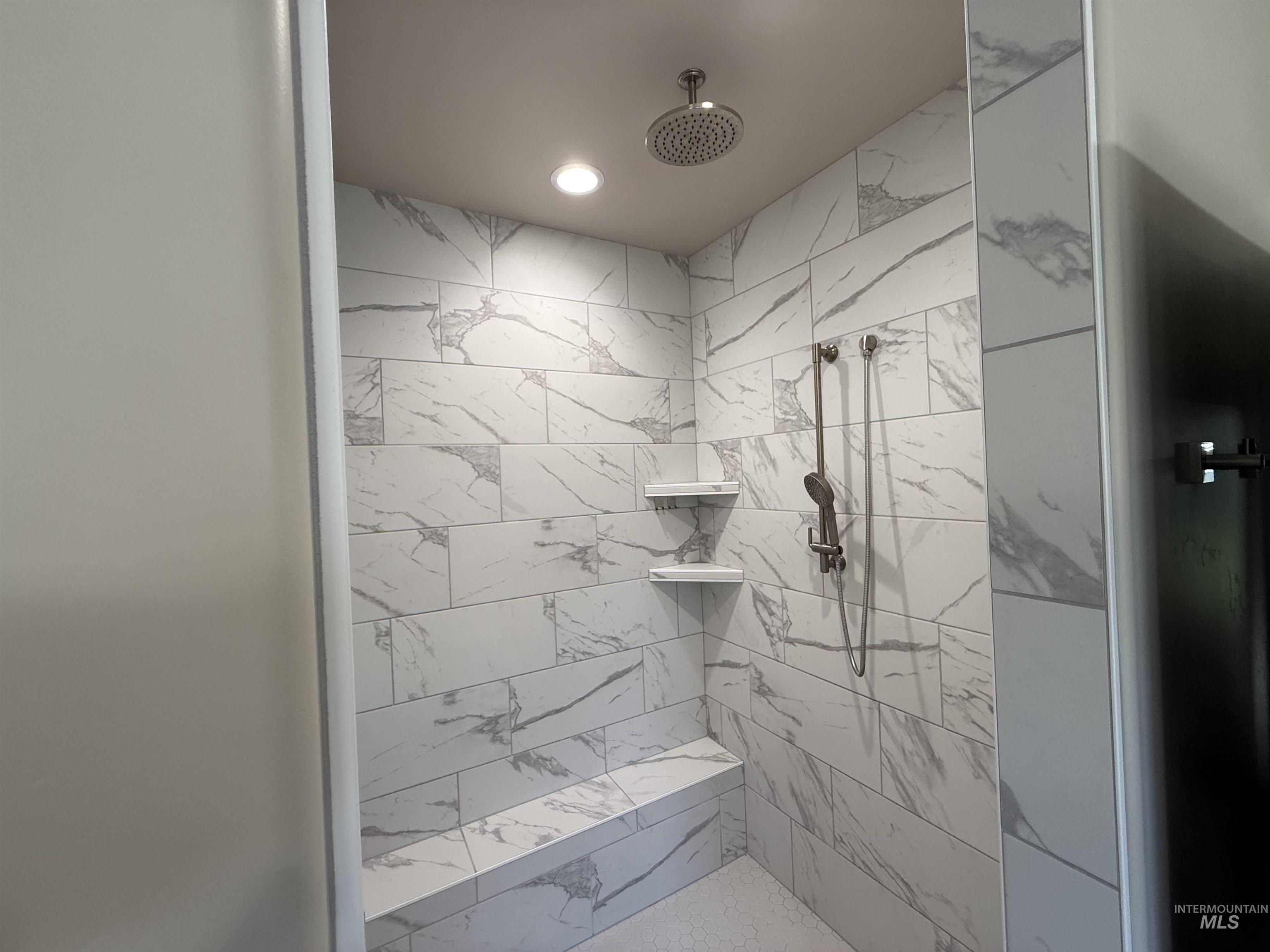 Bathroom featuring a marble finish shower and recessed lighting
