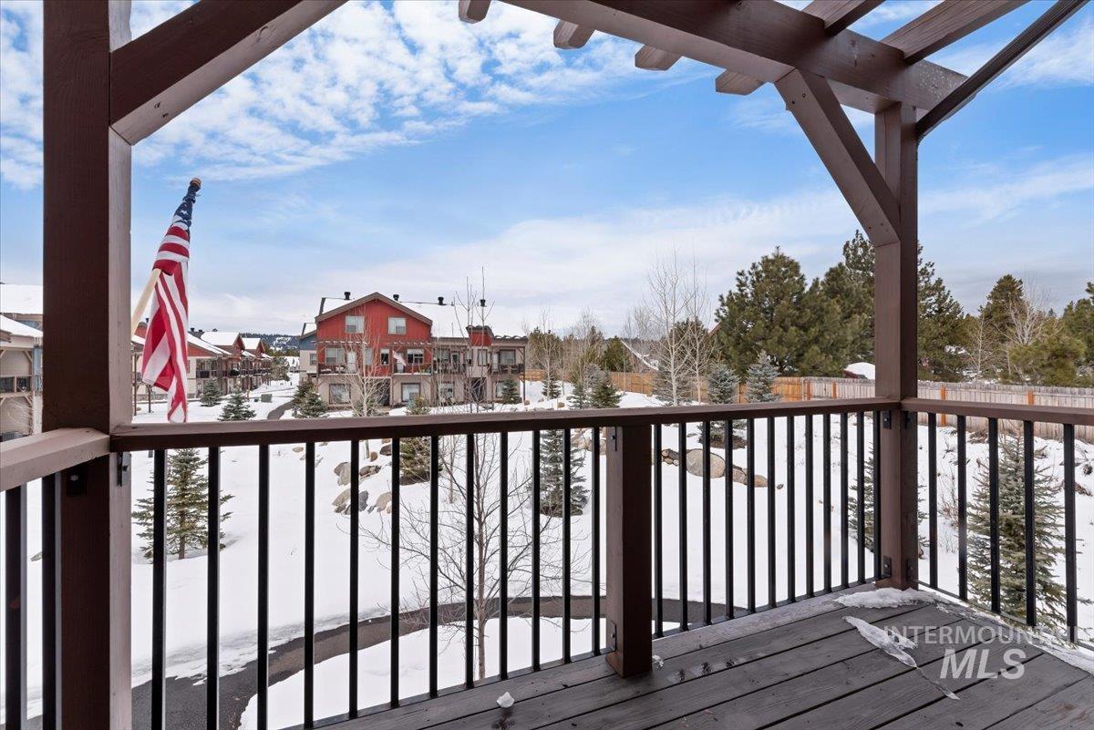 Snow covered deck featuring a balcony and a residential view