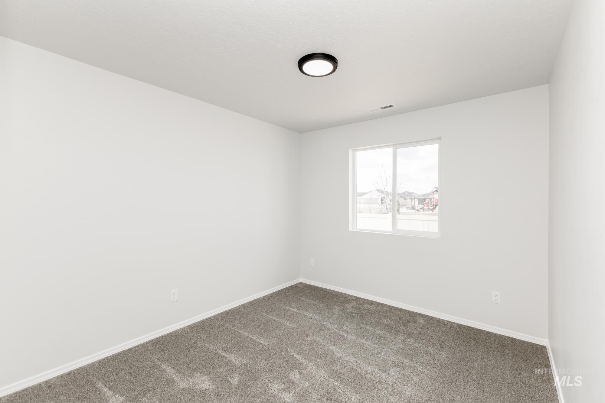Carpeted spare room with baseboards