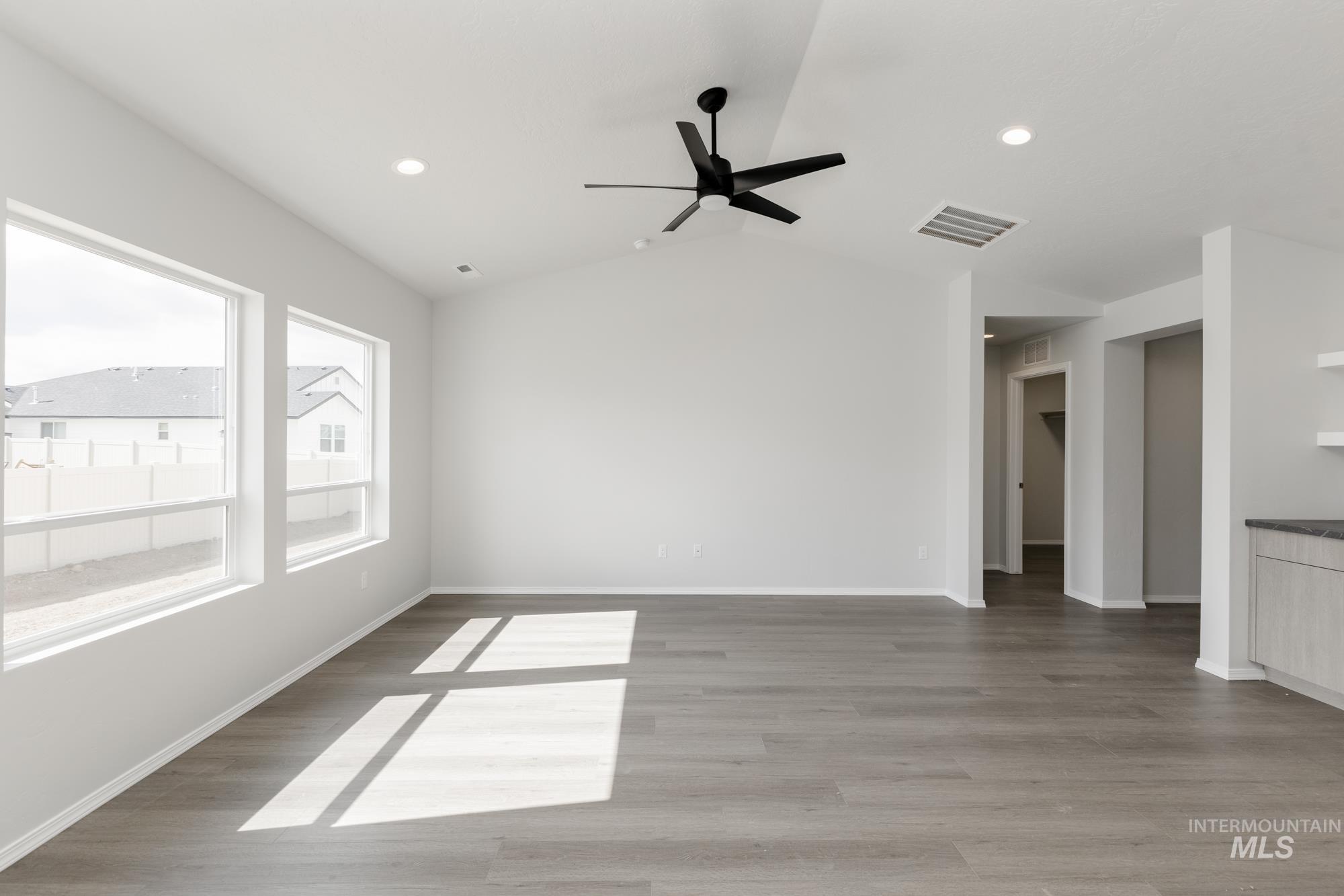 Unfurnished room featuring light wood finished floors, vaulted ceiling, ceiling fan, and recessed lighting