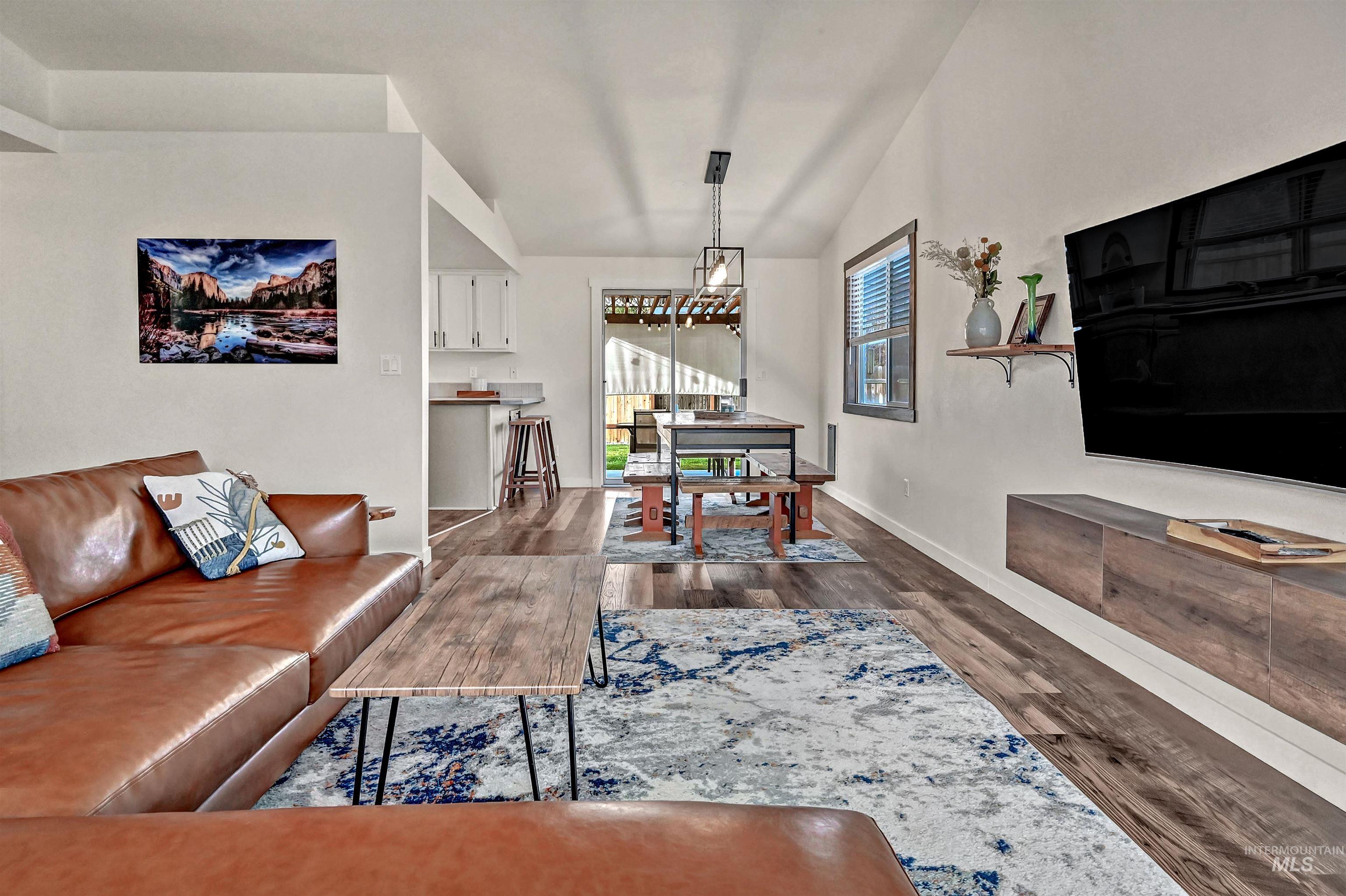 Living room featuring lofted ceiling and dark wood-style flooring