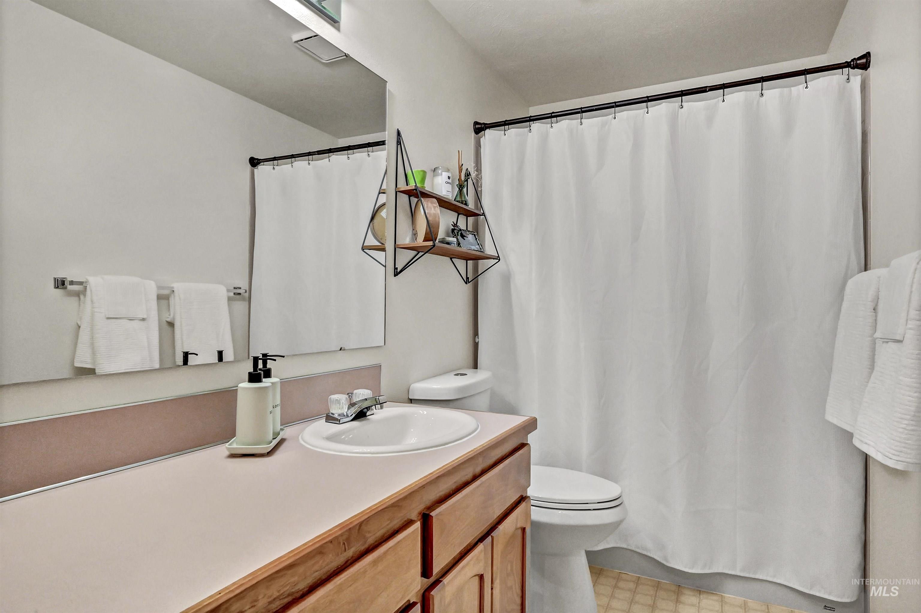 Bathroom featuring vanity and curtained shower