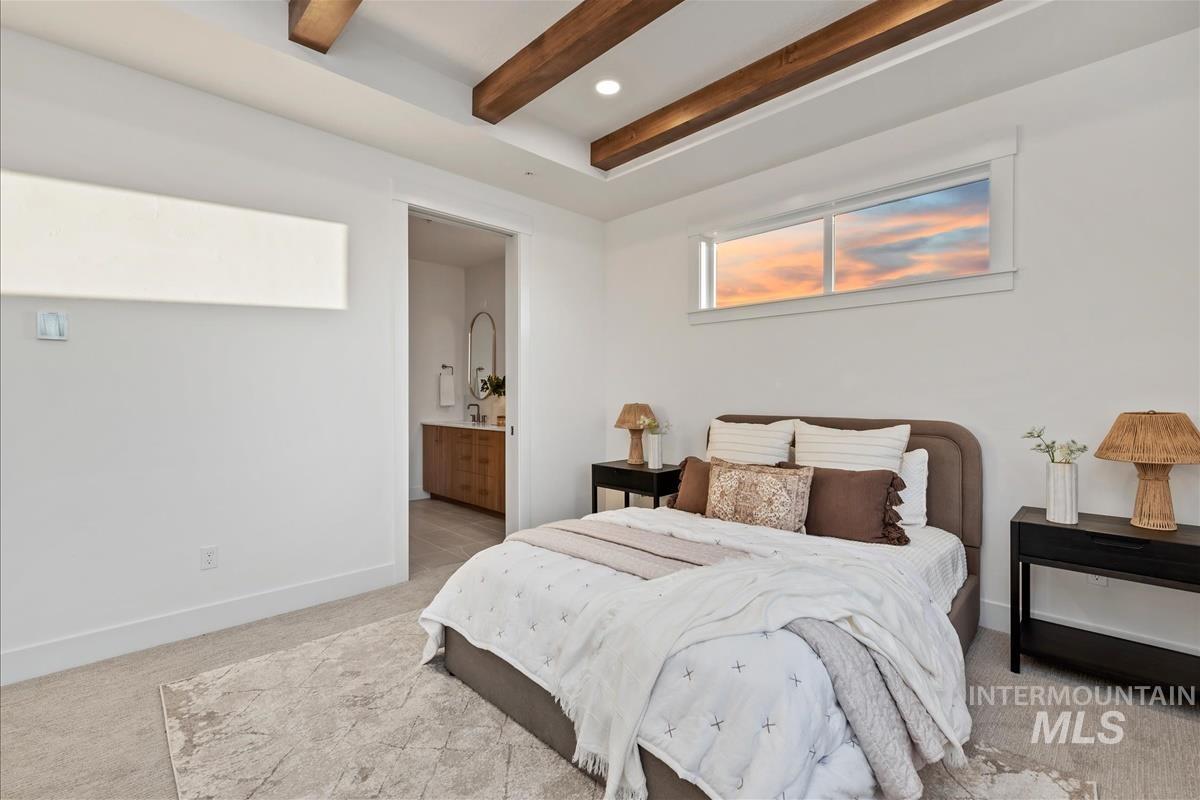 Bedroom with tray ceiling, exposed wood beams, and recessed lighting