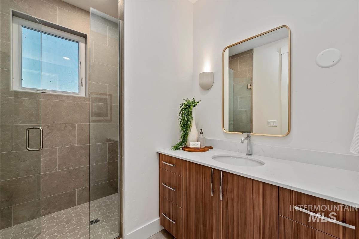 Tiled shower enclosure featuring a clear glass door and window