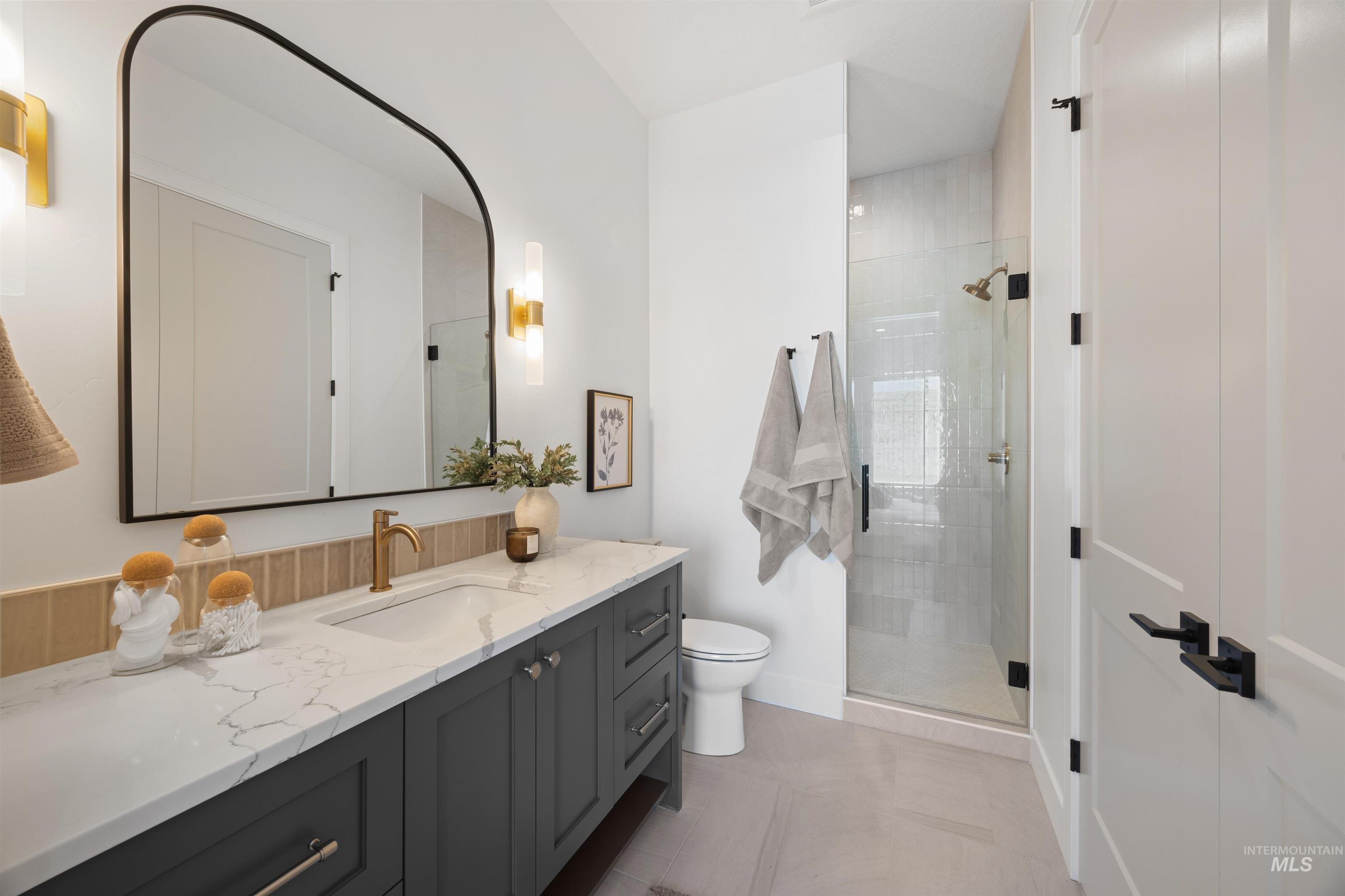 Bathroom featuring vanity, a shower stall, and light tile patterned floors