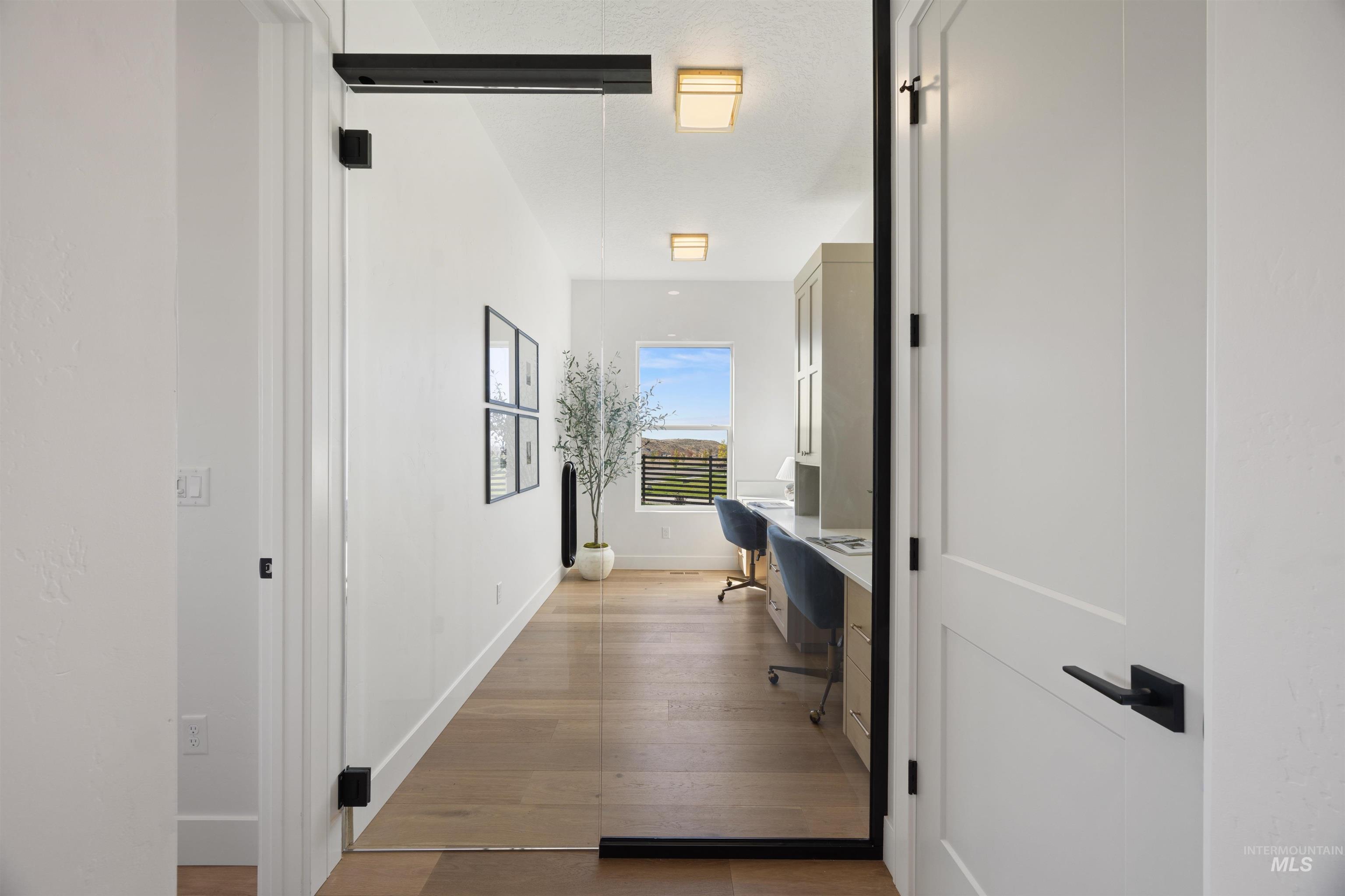 Hallway featuring an office area and light wood-style floors