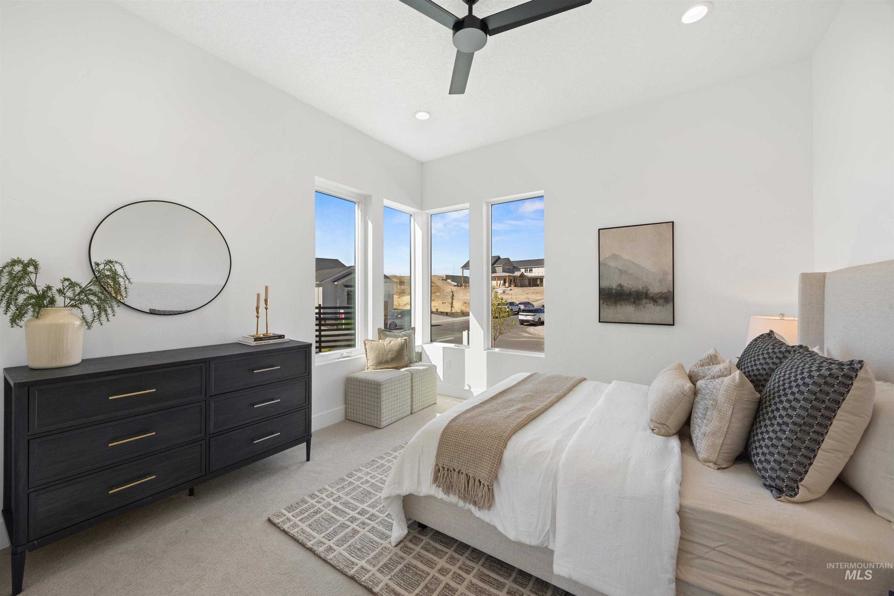 Bedroom with light carpet, ceiling fan, and recessed lighting