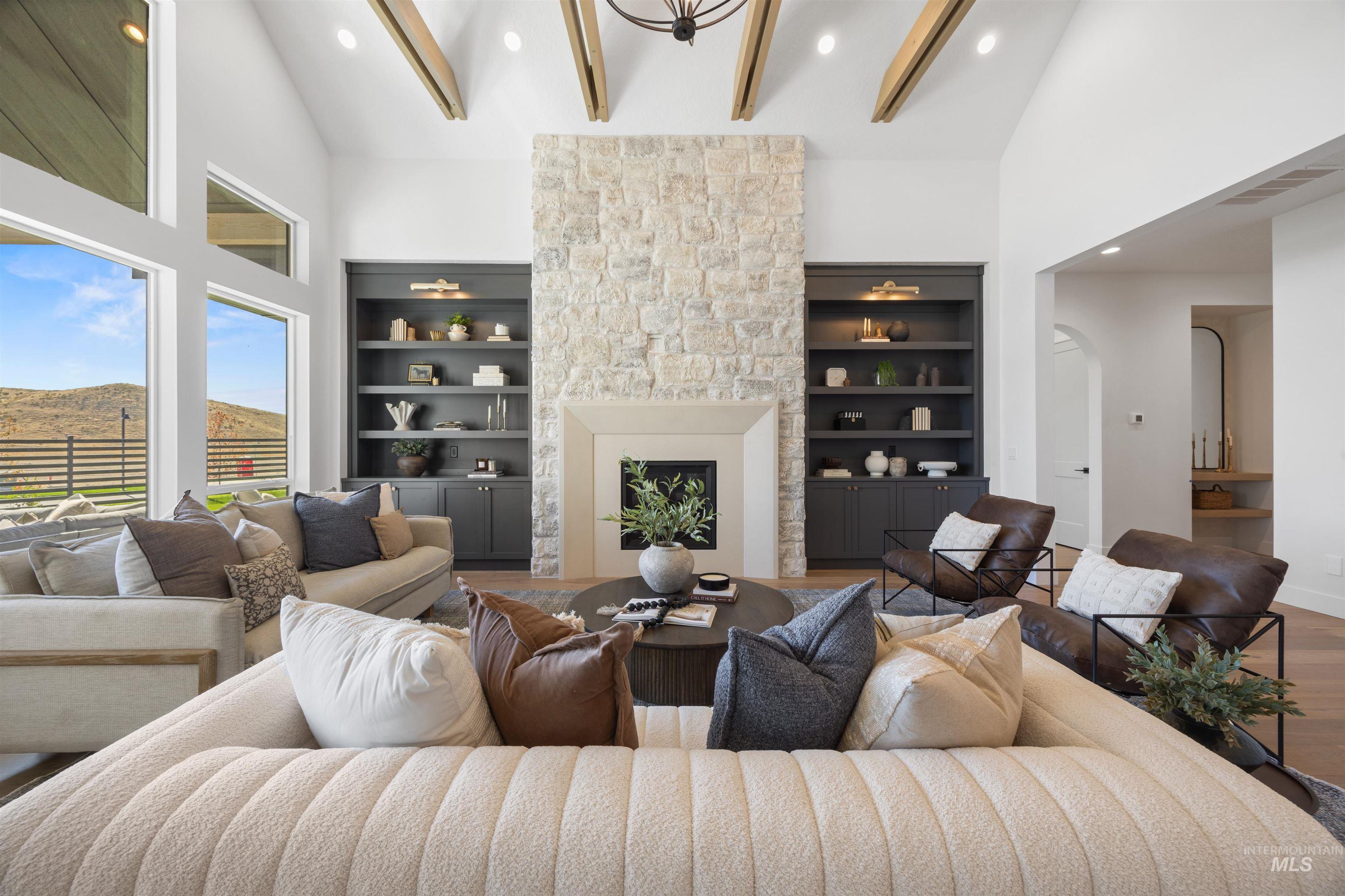Living area featuring high vaulted ceiling, recessed lighting, a fireplace, wood finished floors, and arched walkways