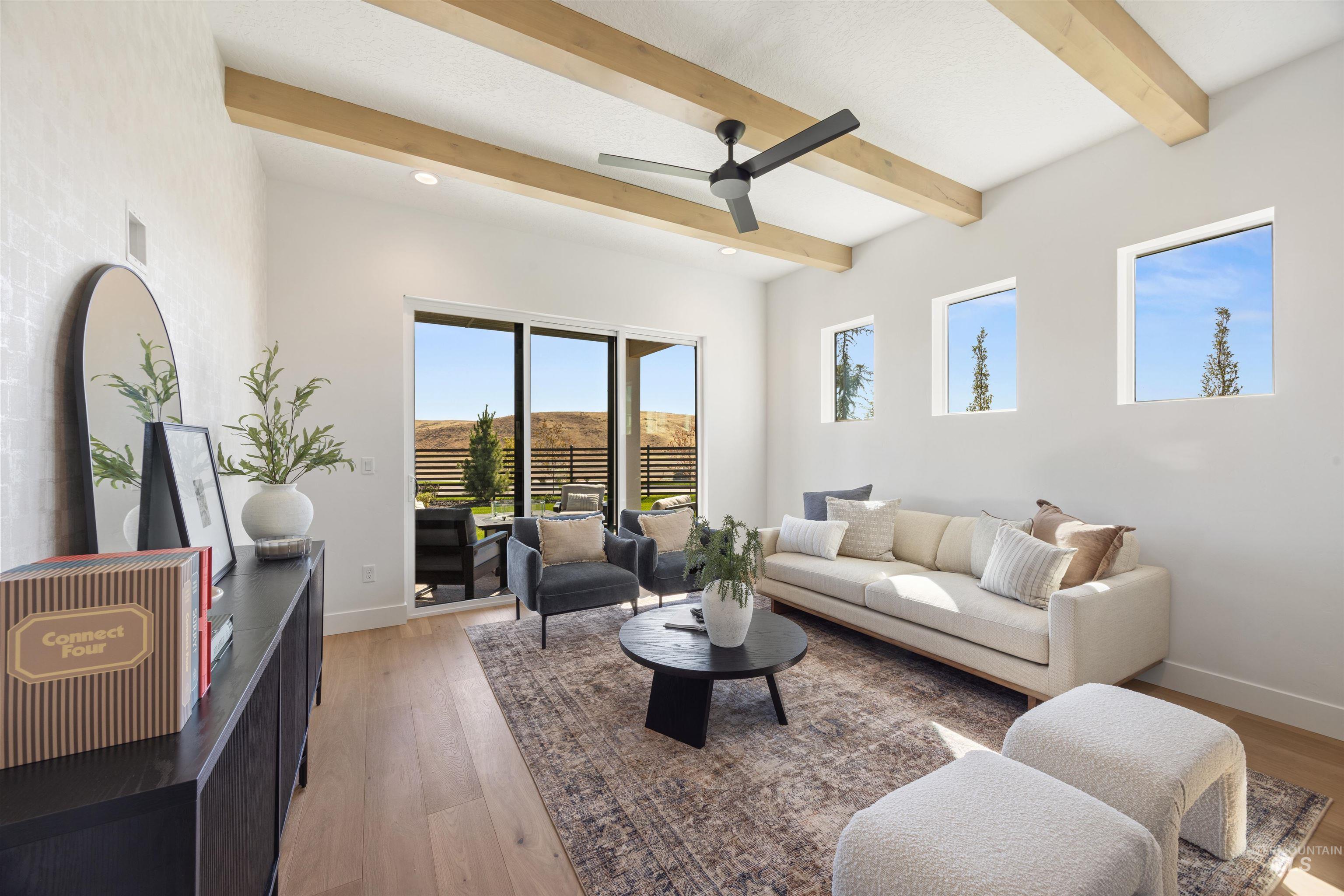 Living area with light wood-type flooring, ceiling fan, and beamed ceiling