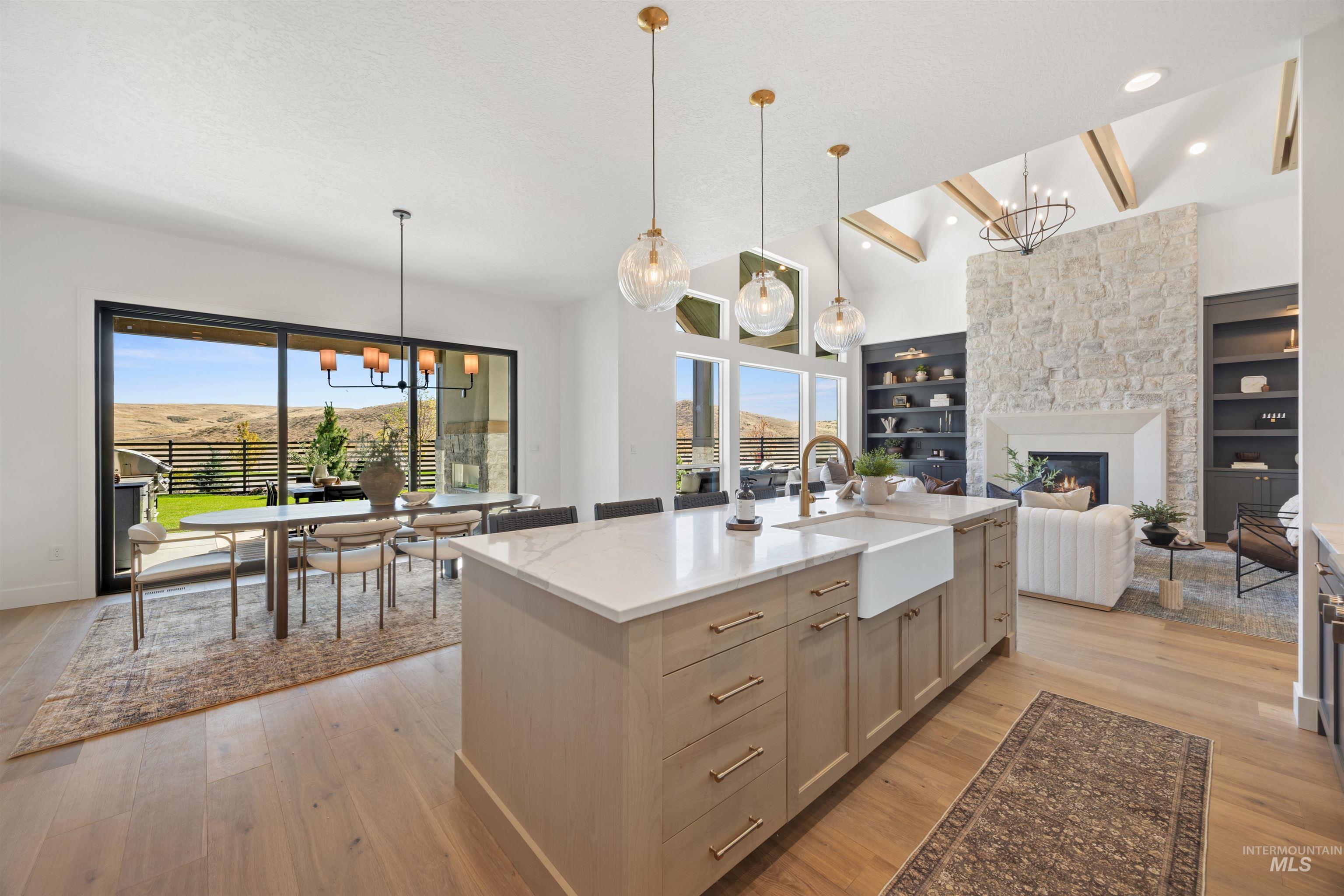 Kitchen with a chandelier, light stone counters, and pendant lighting