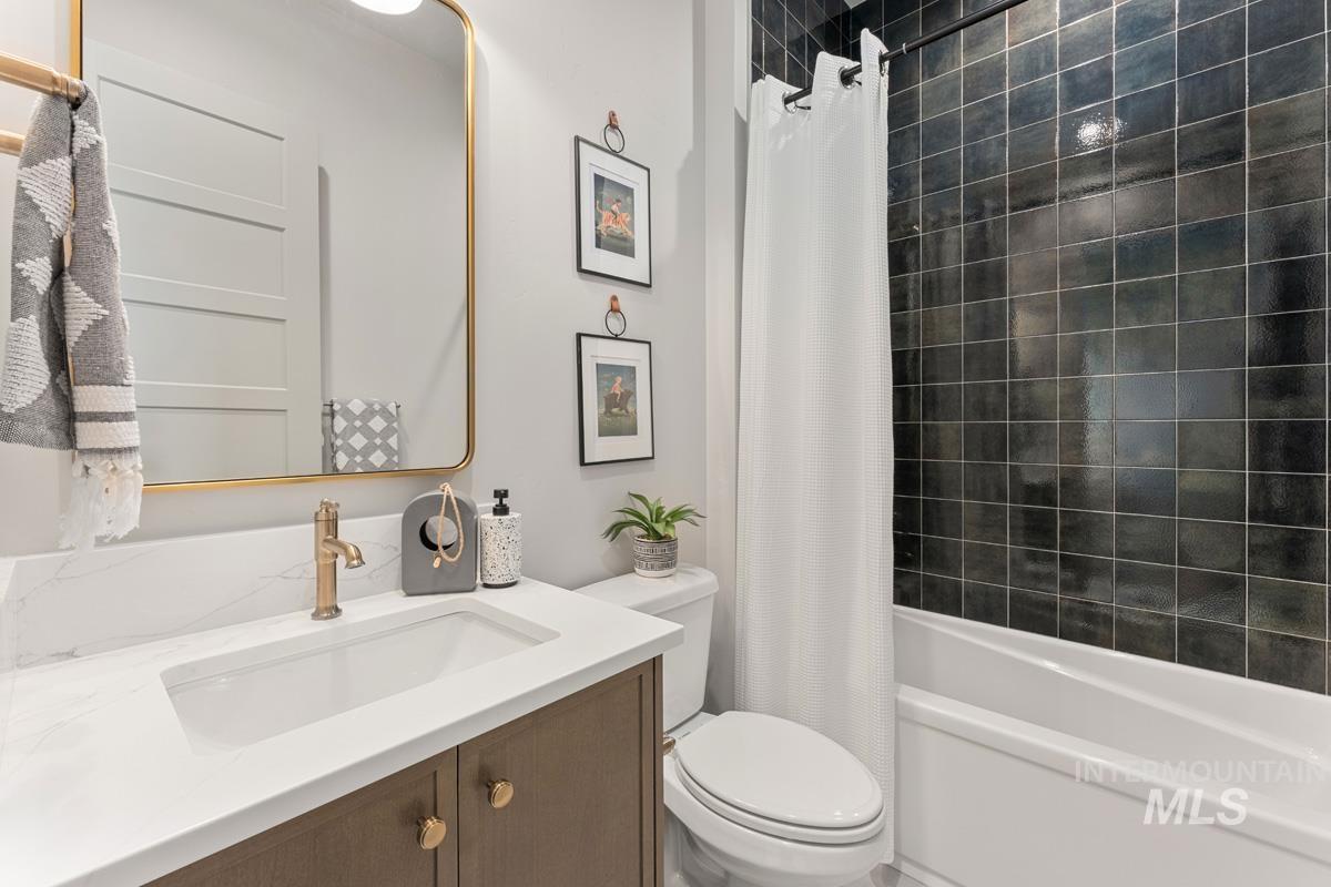 Bathroom featuring vanity and shower / bath combination with curtain