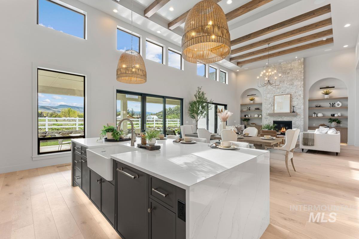 Kitchen with dark cabinetry, a spacious island, open floor plan, built in shelves, and light wood finished floors