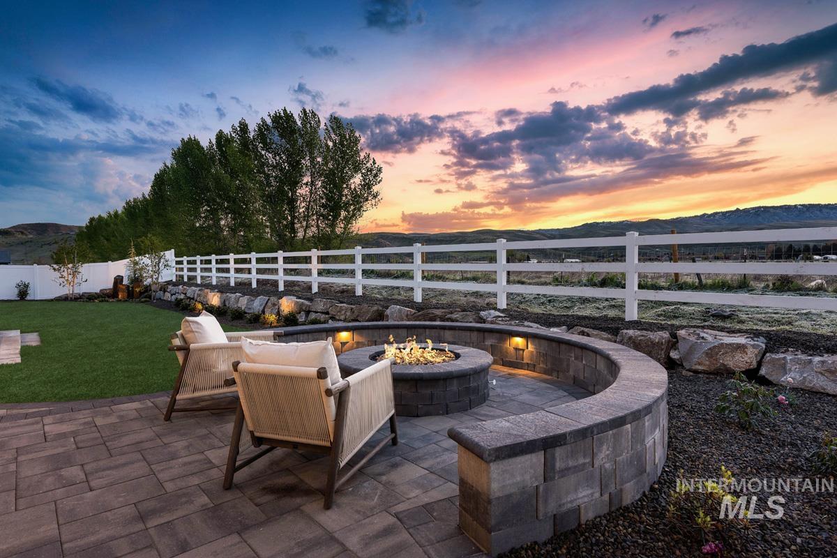Fenced backyard featuring a mountain view, a fire pit, and a patio area
