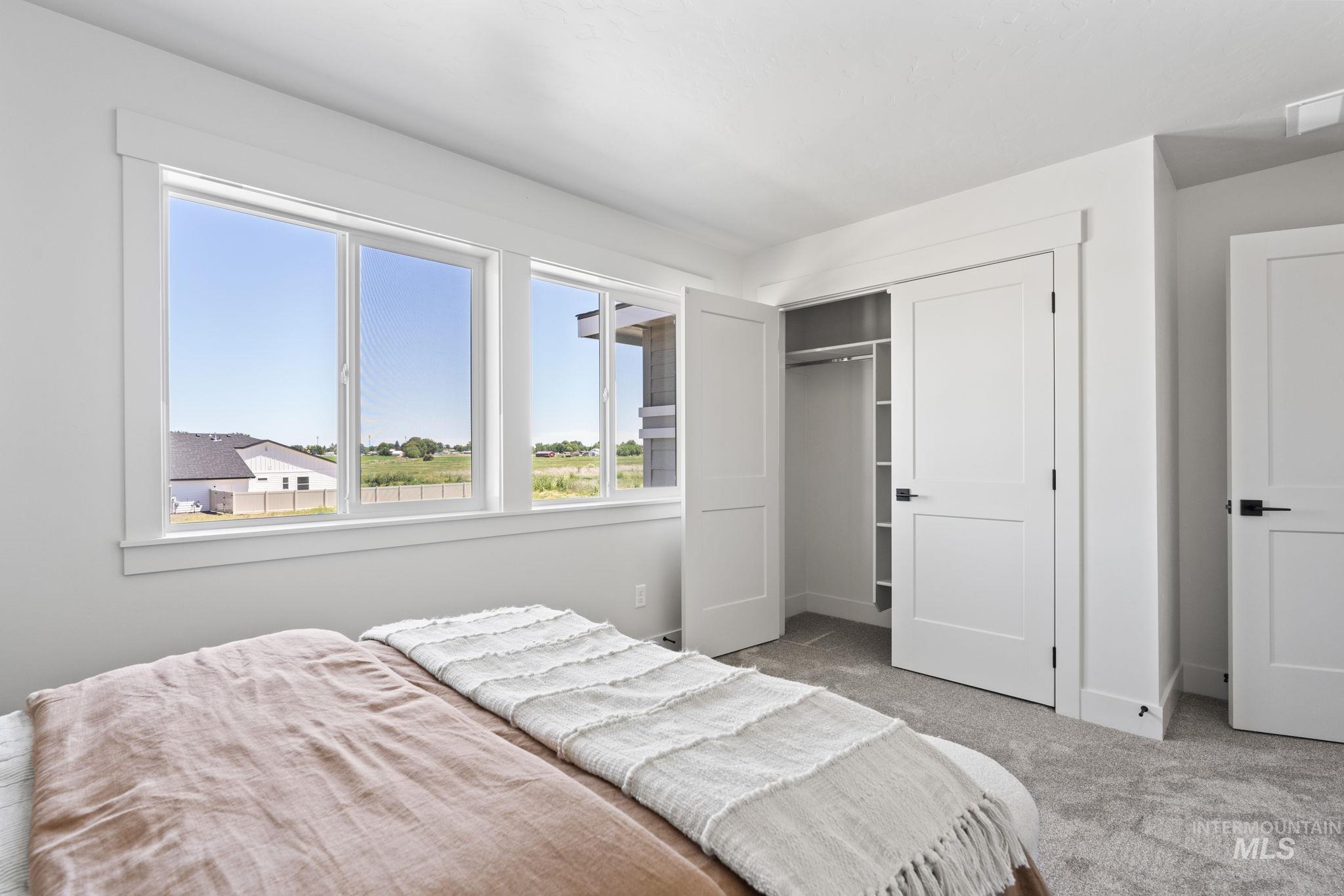 Bedroom with light carpet and a closet