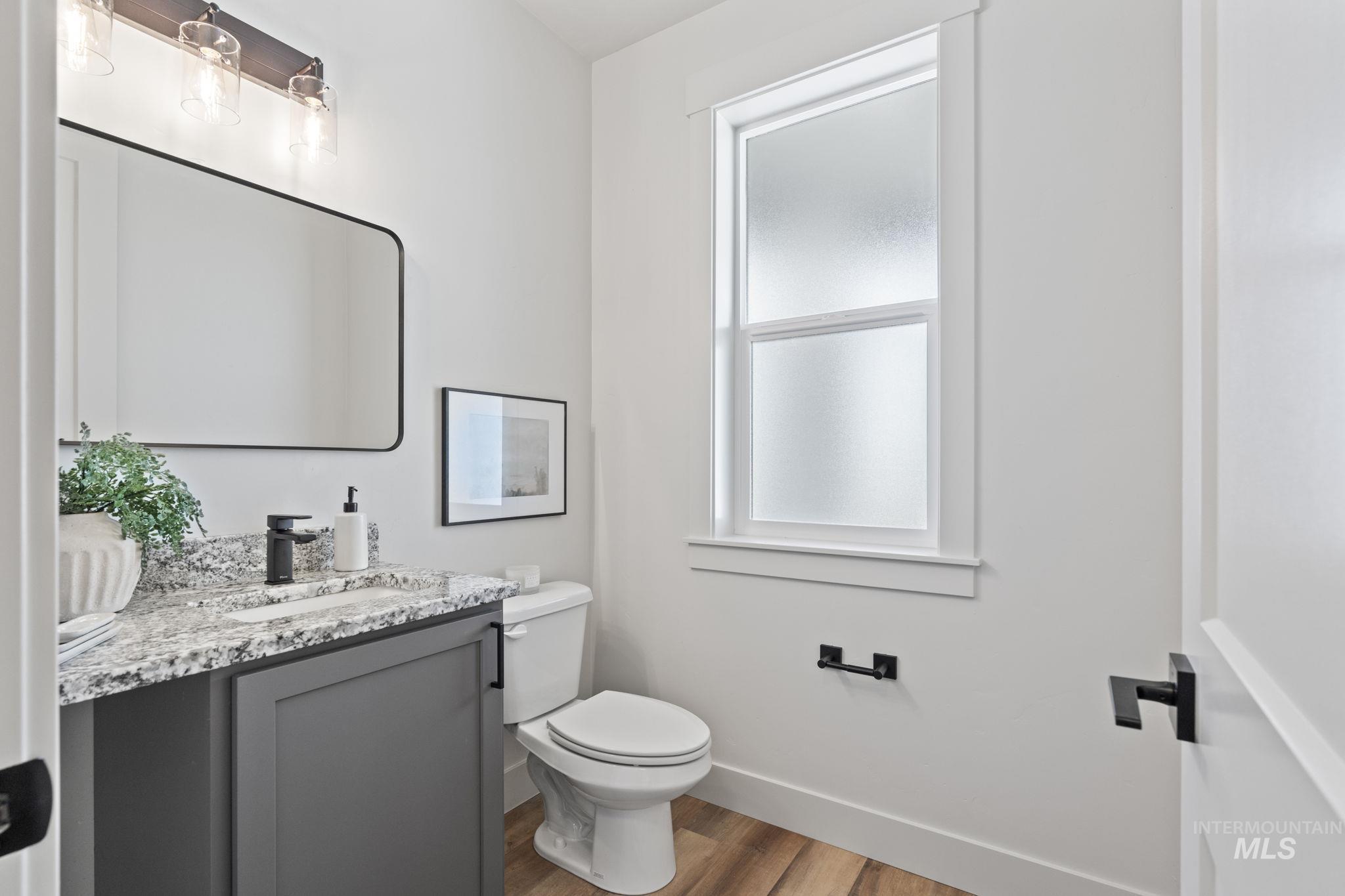 Half bathroom featuring vanity and dark wood-style floors