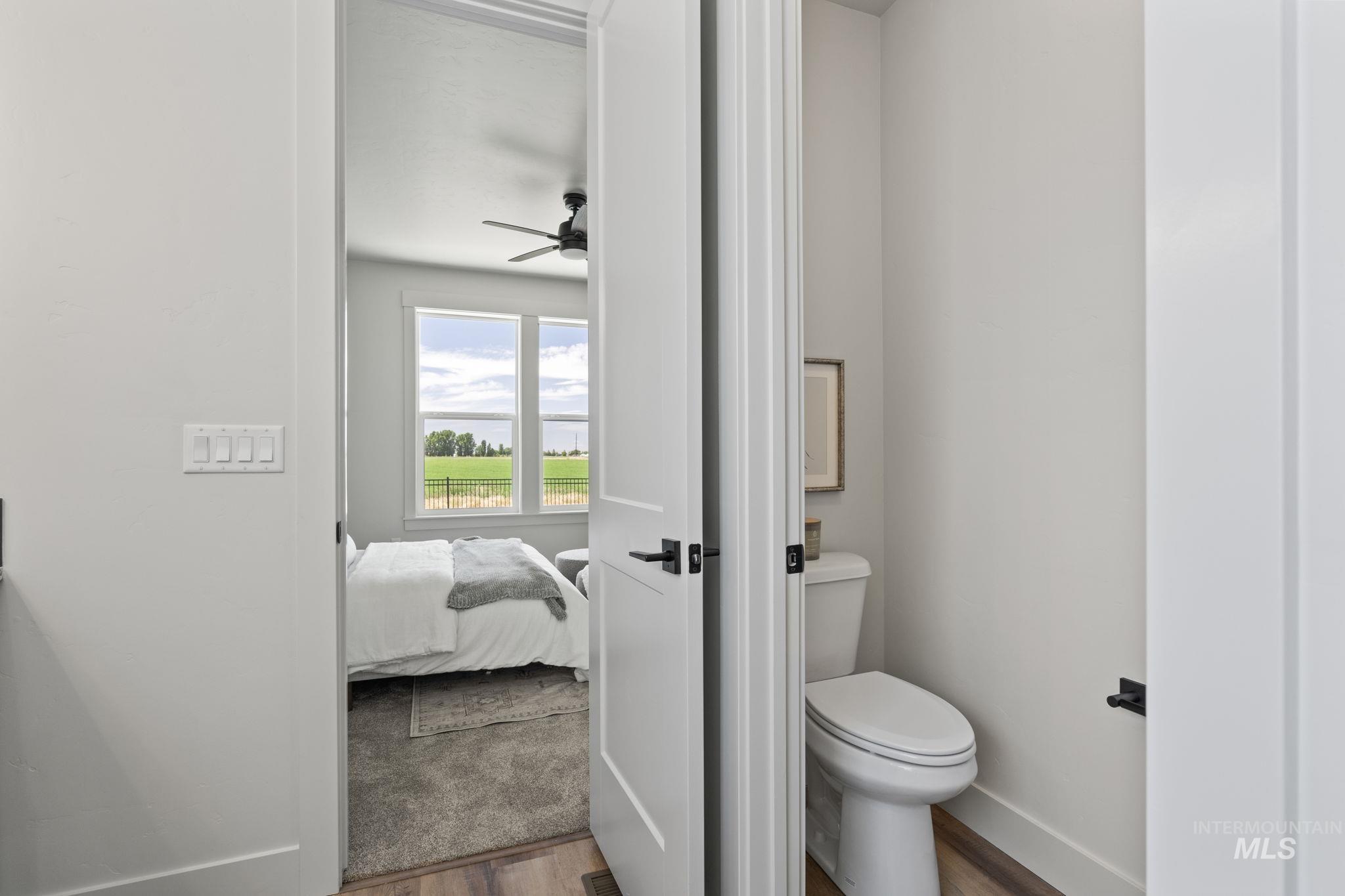 Bathroom with wood finished floors, ceiling fan, and connected bathroom