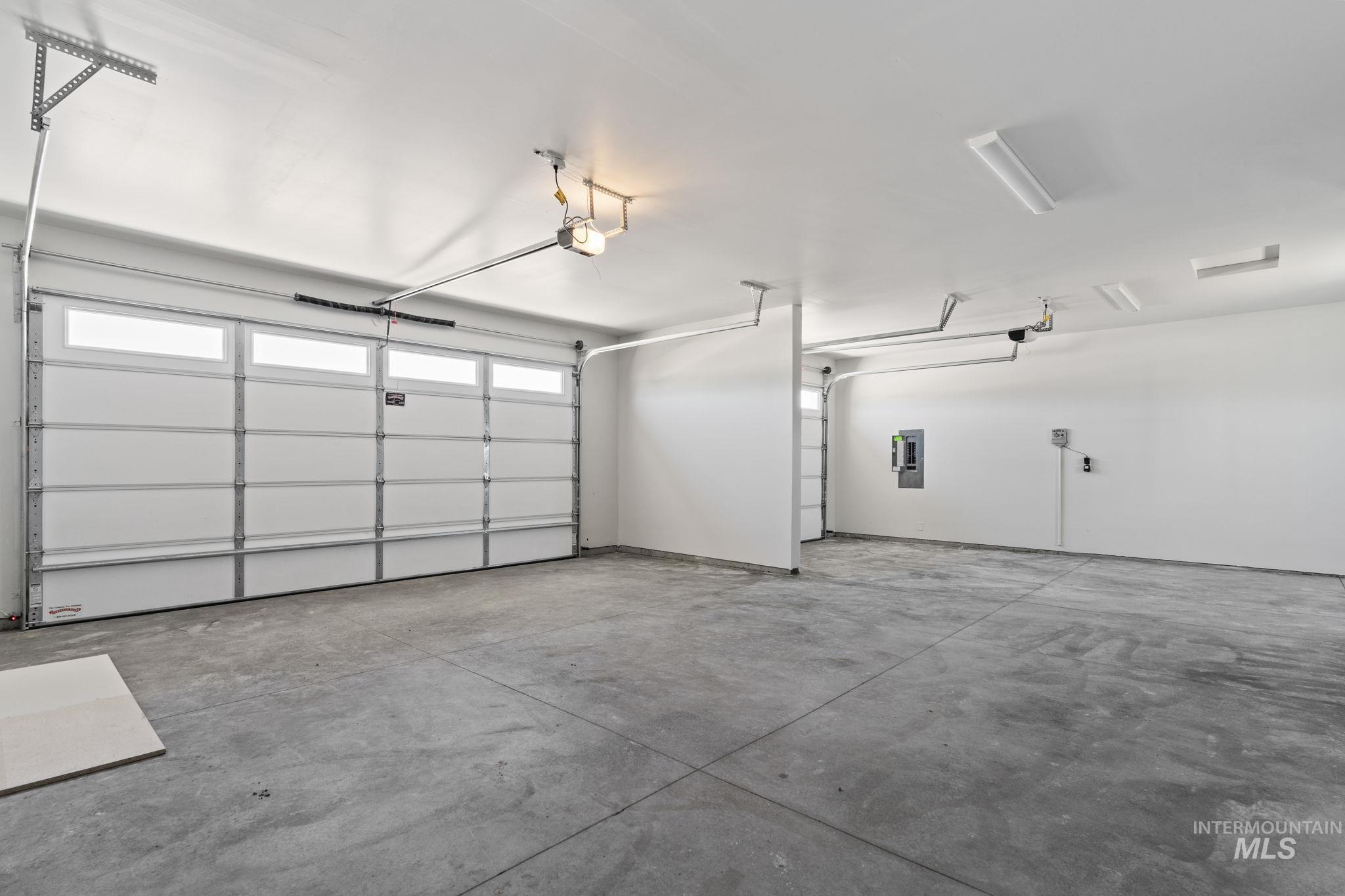 Garage featuring electric panel and a garage door opener
